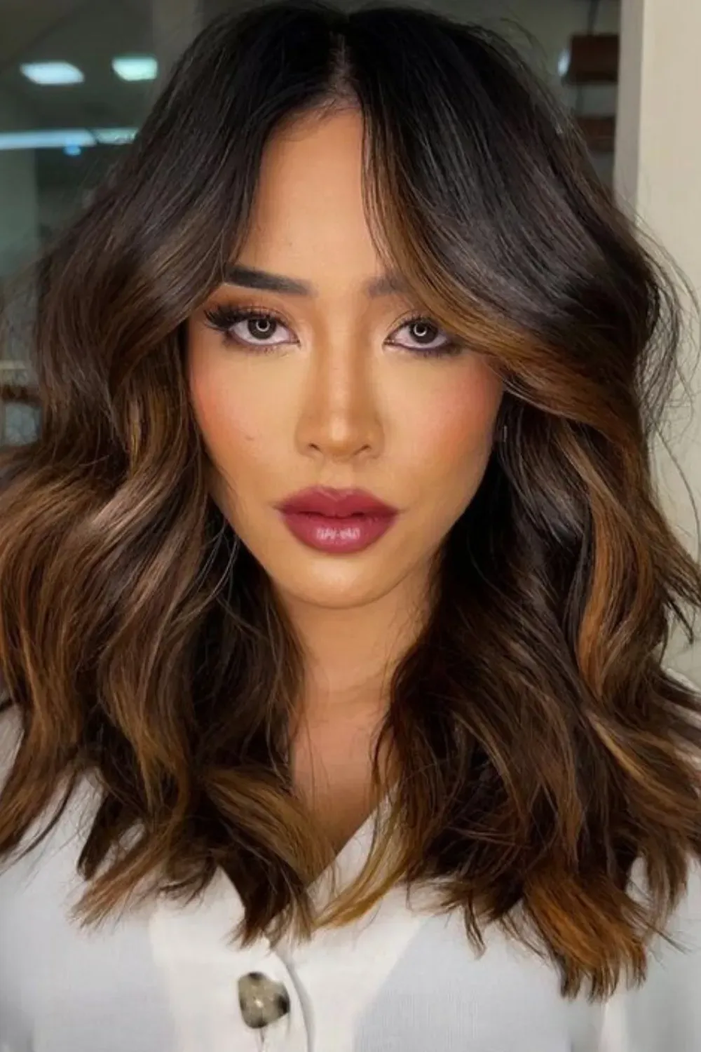 Dimensional Lob with Caramel Ends and Face Frame	Woman with a wavy lob featuring rich caramel color concentrated at the ends and face frame.