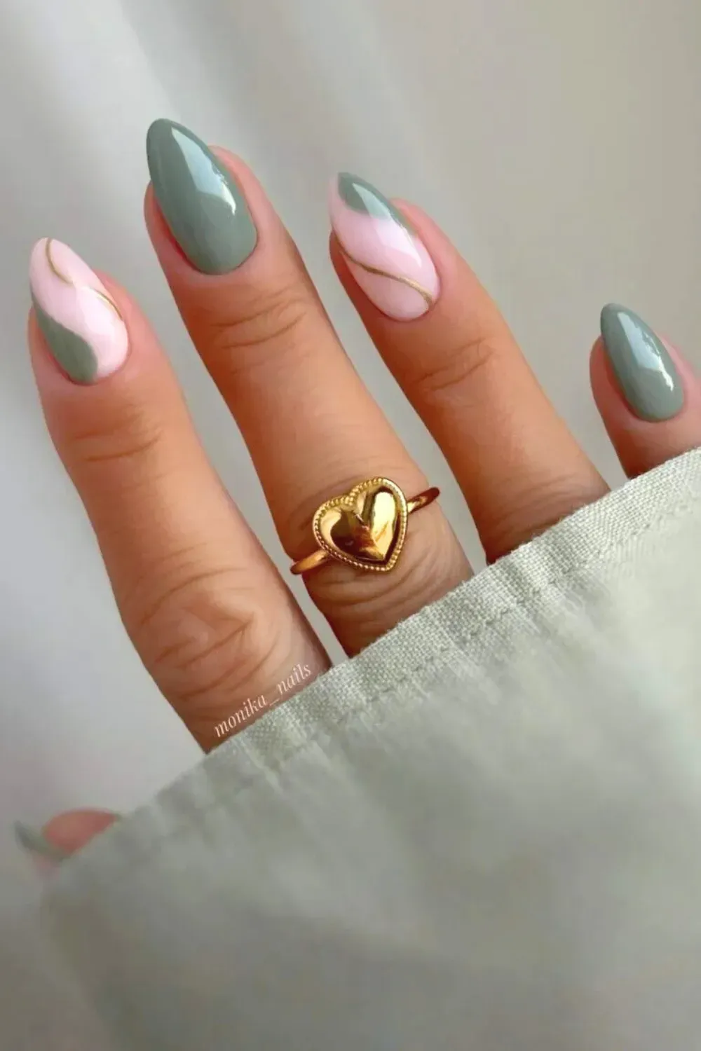 Sage and Pink Split Manicure with Gold Line - Long almond nails with a diagonal color block of slate green and pale pink, separated by a delicate gold stripe.