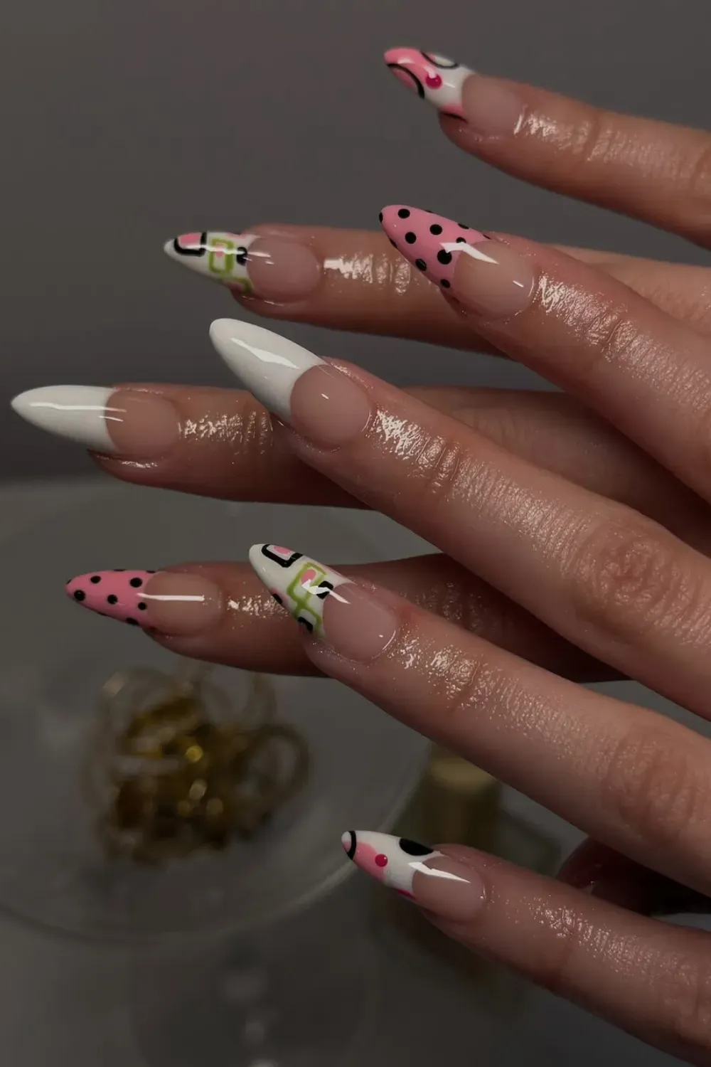 Abstract Geometric Stiletto Nails Alt Text: Stiletto nails with pink and green abstract geometric pop art.