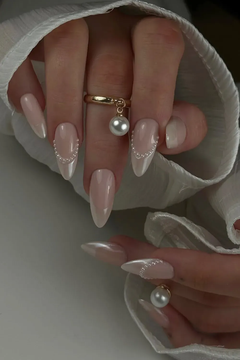 Pearl Coquette French Nails Alt Text: Pearlescent white french tips with draped pearl strings.