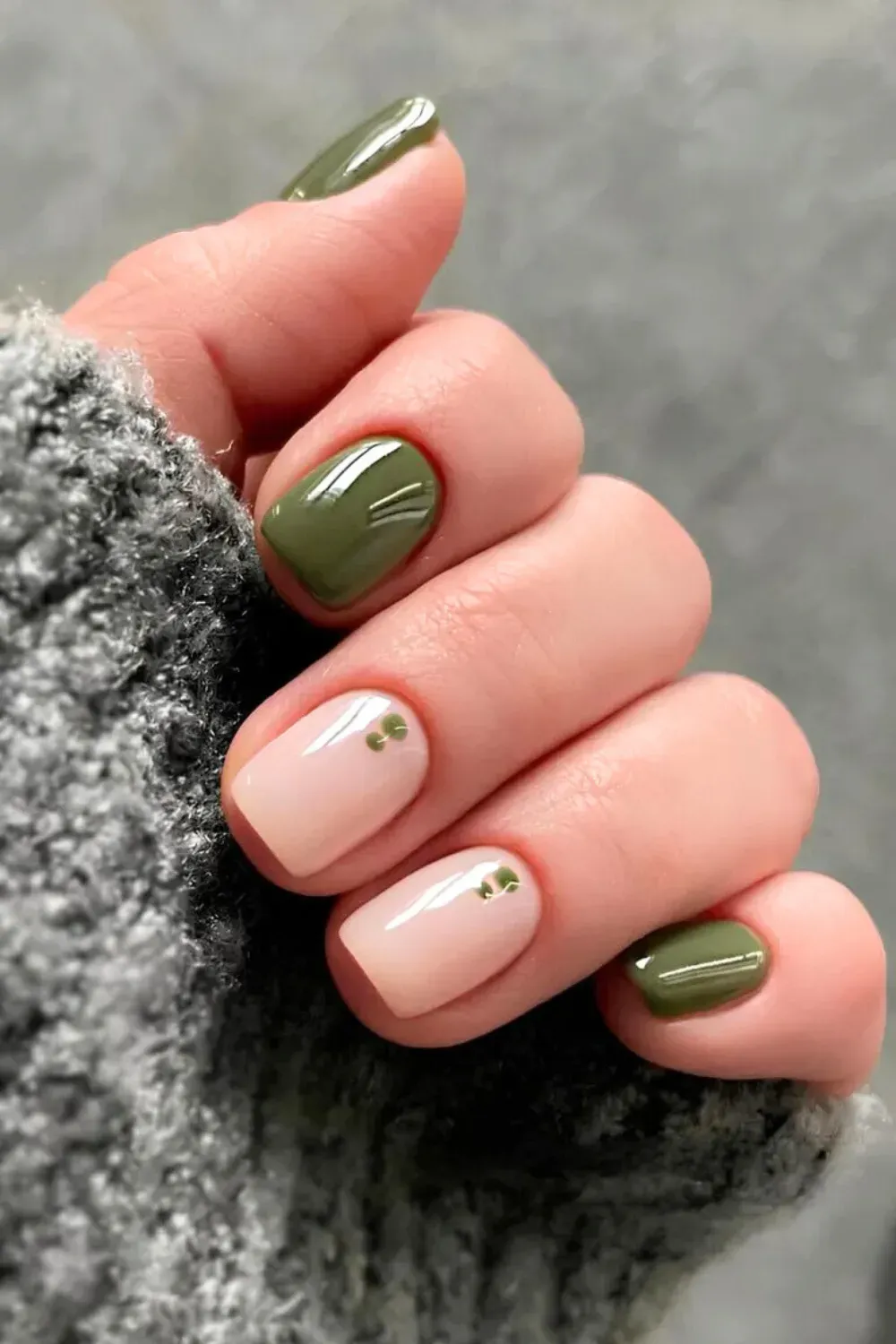 Olive Green and Sheer Nails with Clover Accent - Short squoval nails with solid olive green and sheer pink featuring a tiny clover decal accent.