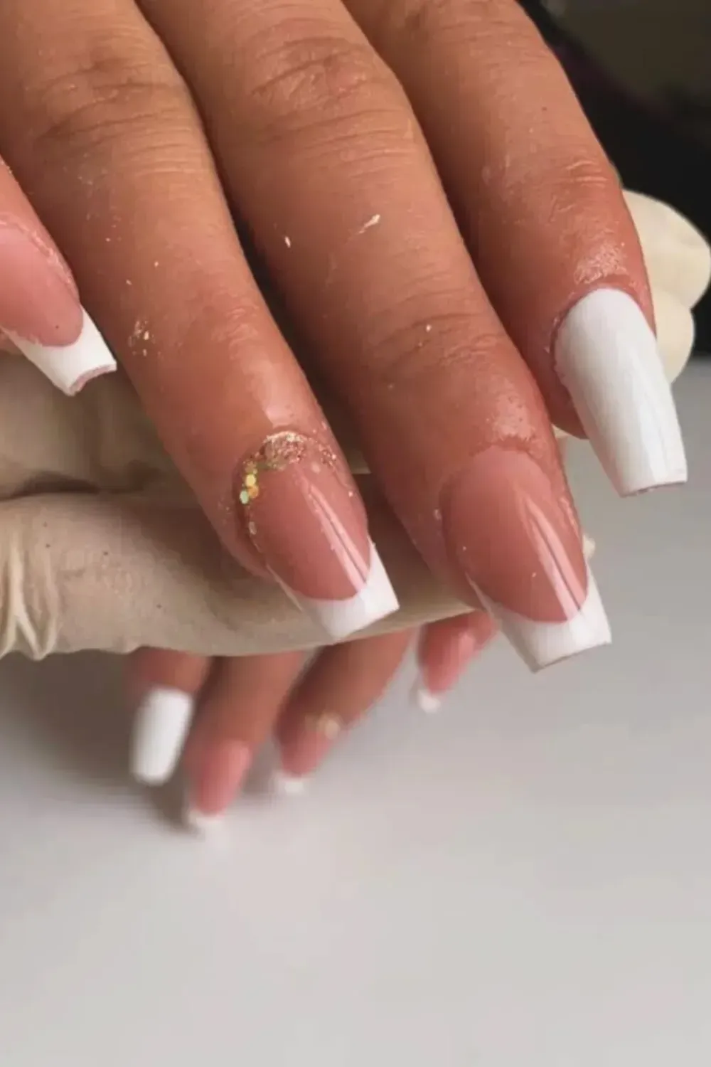 Classic White Square French with Glitter Detail: White square French tip nails with a subtle gold glitter accent.