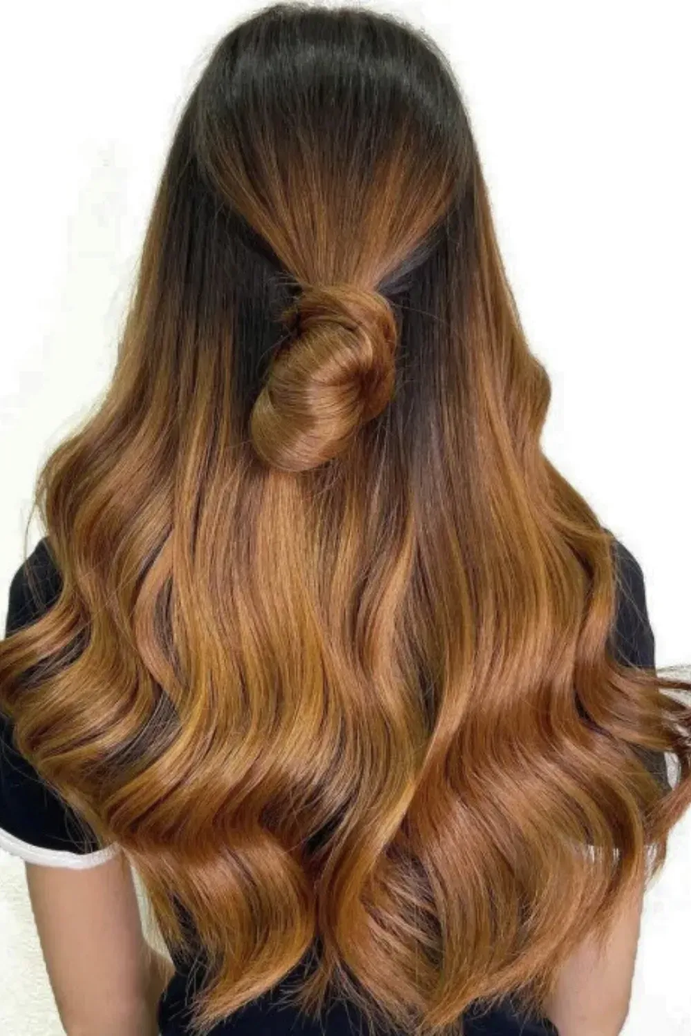 Intense Copper Caramel Ombre on Long Hair	Back view of long, wavy hair with a deep dark root melting into a bright, vibrant copper-caramel ombre.