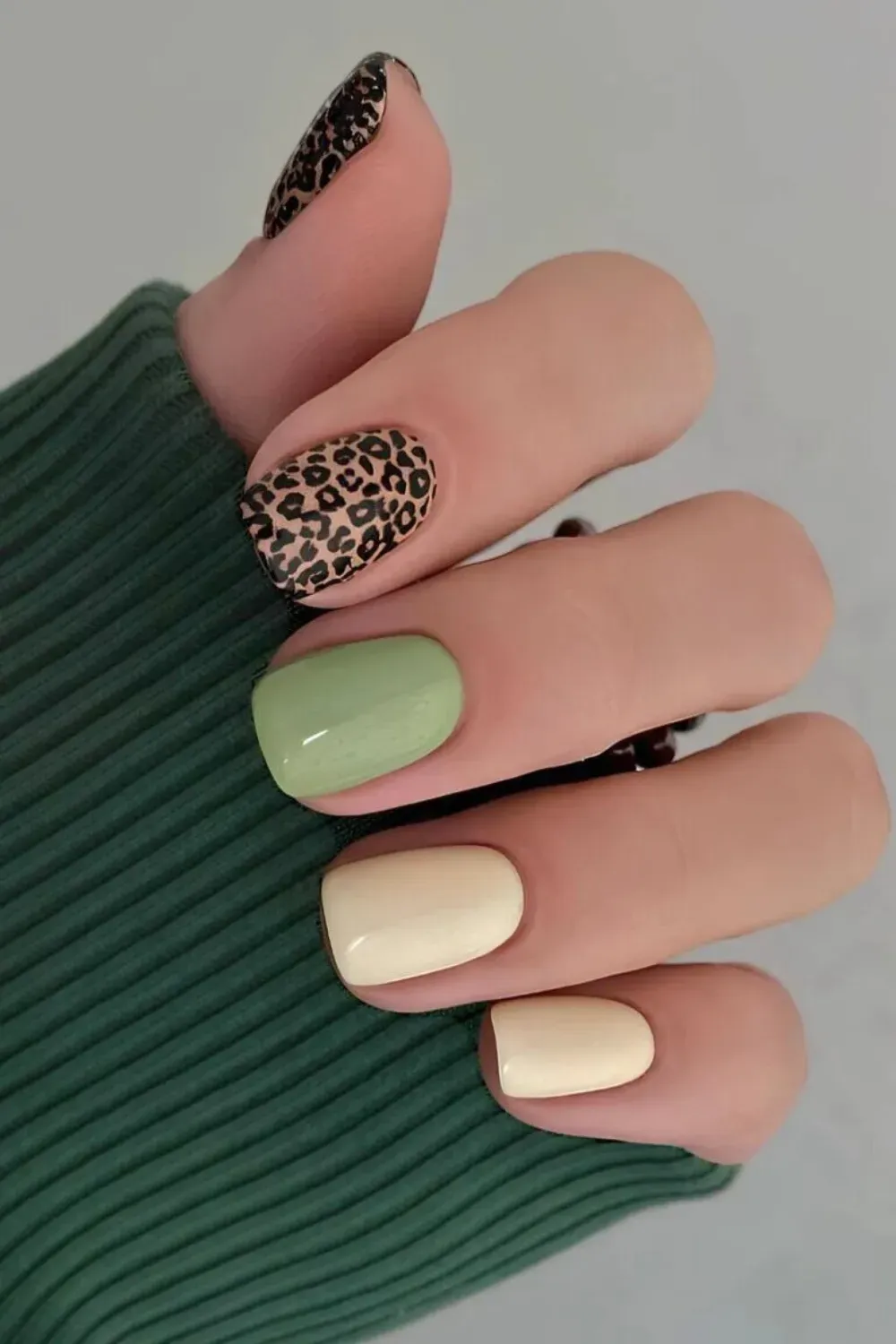 Pistachio Green and Cream with Leopard Print Accent - Short square nails with solid pistachio and cream colors, accented with a black and brown leopard print nail.