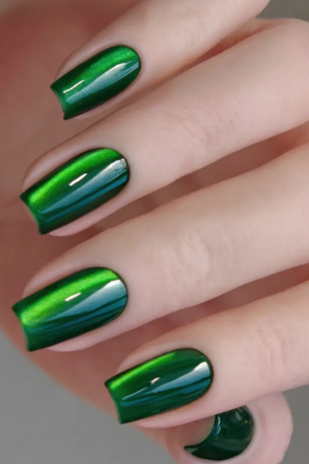 Vivid bold forest green cat eye nail polish on short natural nails