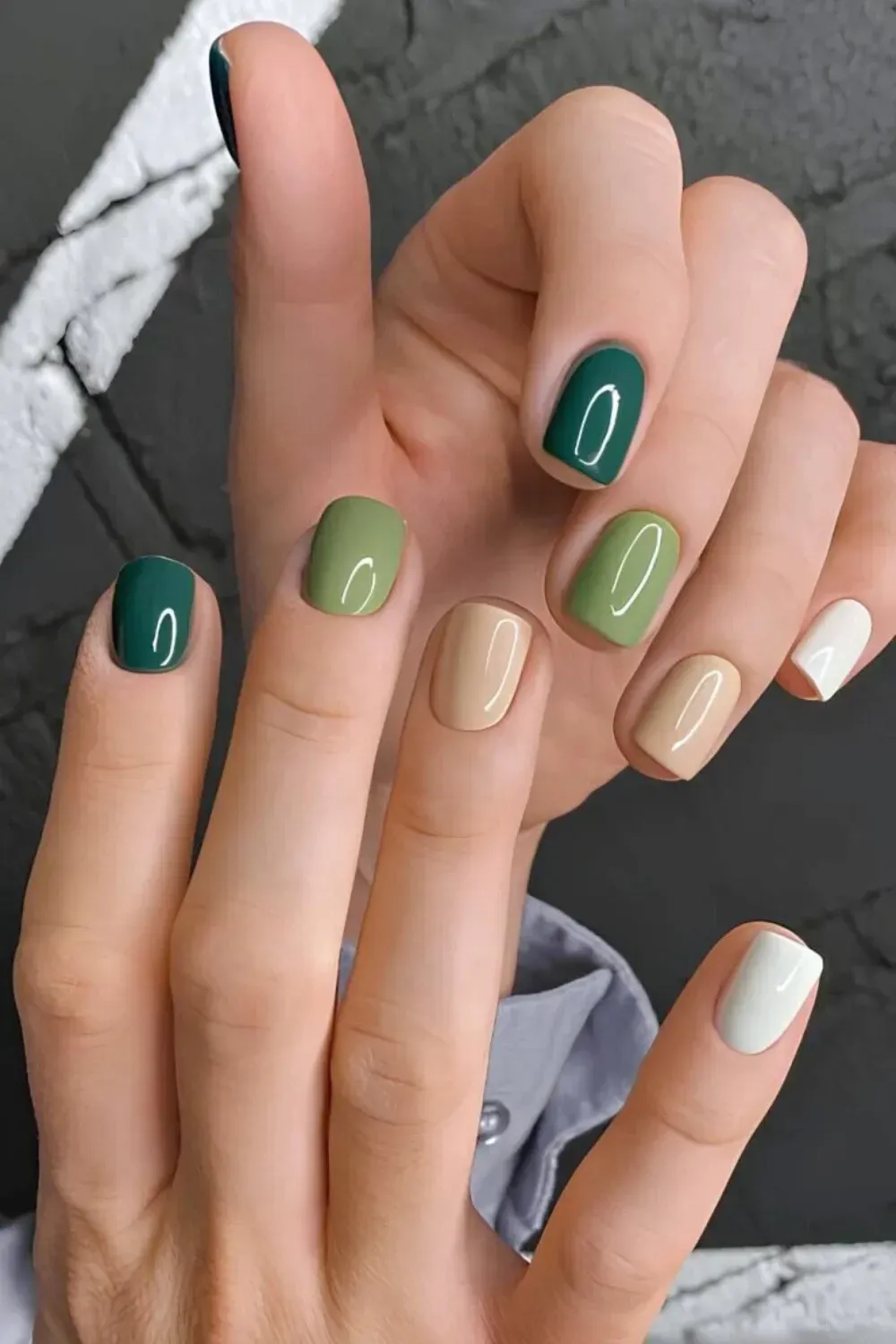 Skittle Manicure in Mixed Green and Neutral Tones - Short square nails painted in contrasting solids: emerald green, olive green, taupe, and white.