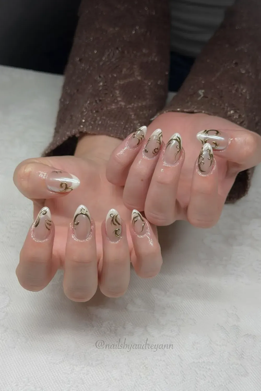 White French With Gold Swirls Alt Text: Classic white french tips overlaid with gold chrome filigree