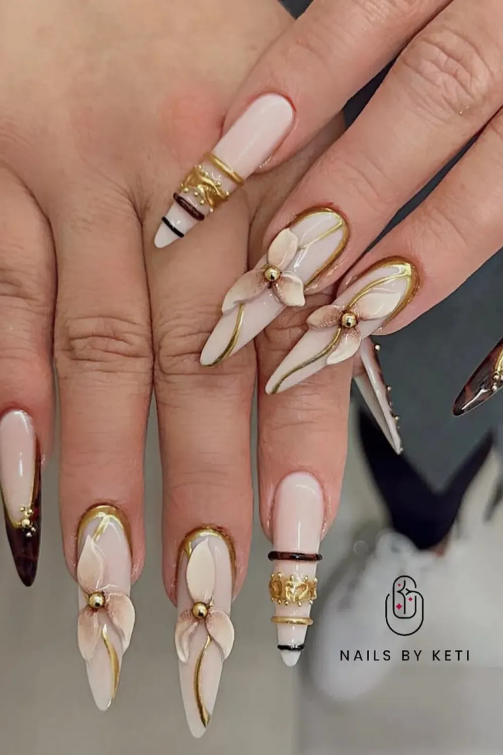 Elegant 3D Flower & Bangle Nails on Nude Stiletto Shape - Highly detailed Bangle Nail look with gold bands, gold chrome tips, and sculpted 3D nude floral art accents.