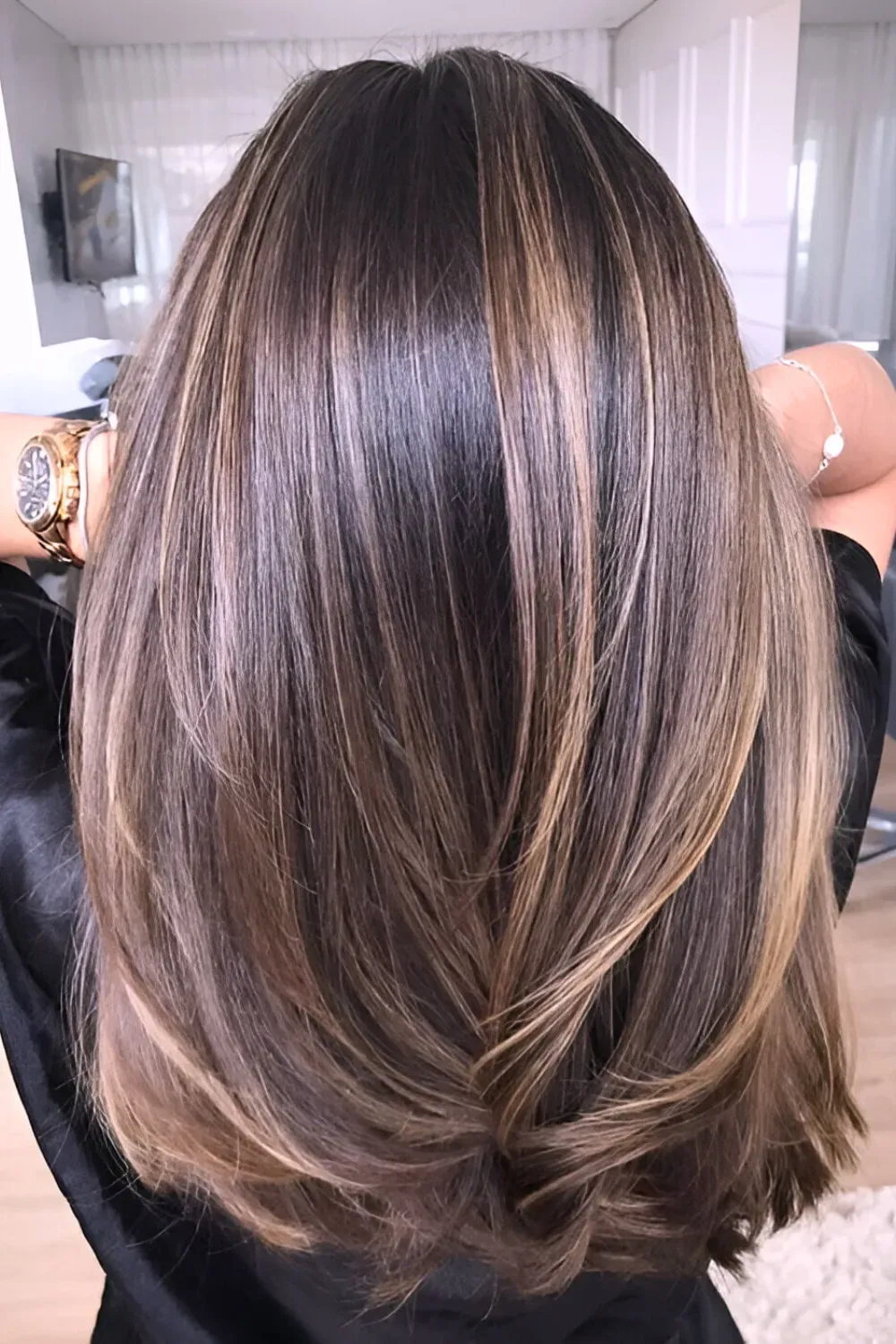 Subtle Caramel Streaks on Layered Medium Hair	Back view of a layered medium brown haircut with fine, polished caramel highlights woven throughout.