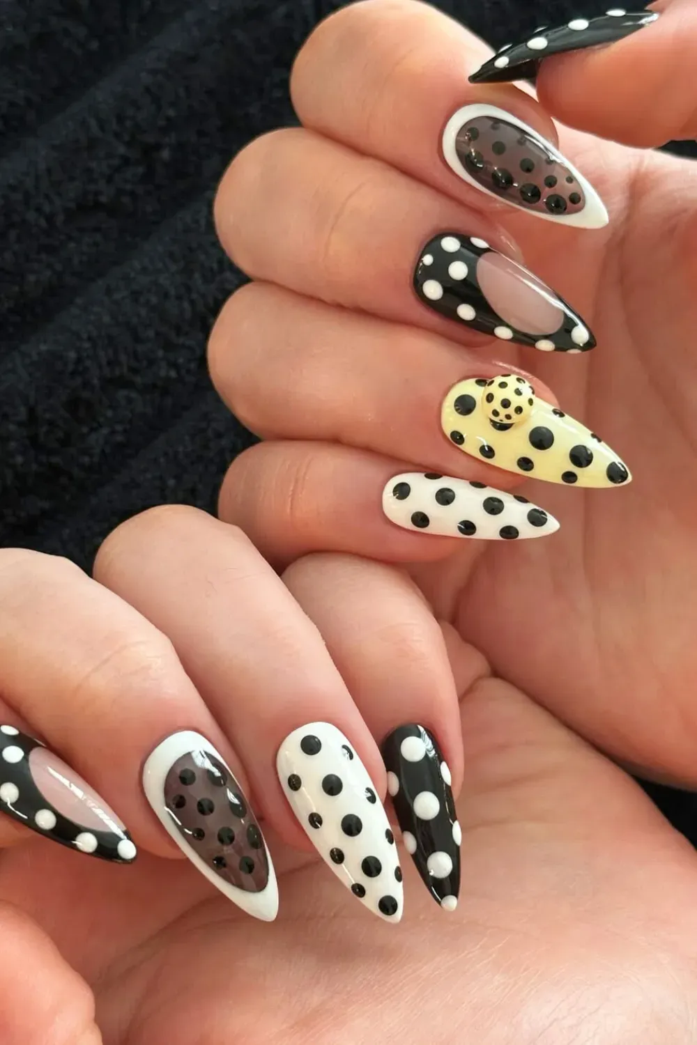 Graphic Yellow Black and White Polka Dot Nails - Stiletto nails featuring black and white polka dot designs contrasted with one bright yellow patterned nail with a 3D element.