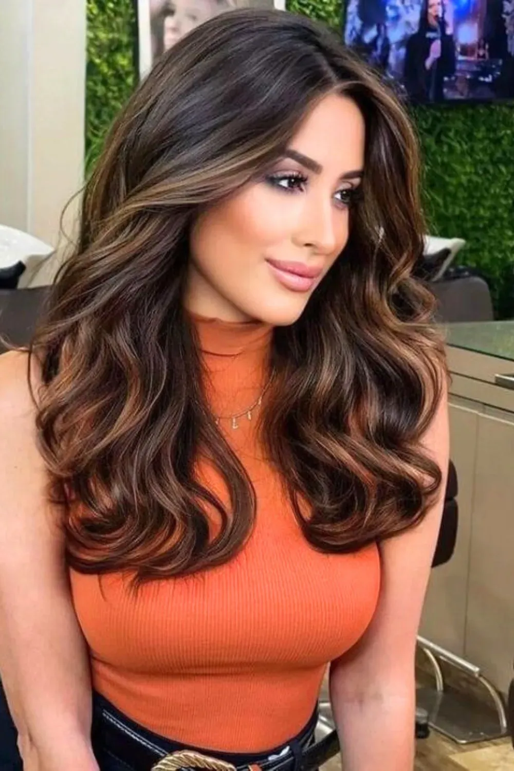 Classy Fiery Curls	Woman with voluminous curls enhanced by warm, reddish-auburn and caramel face-framing highlights