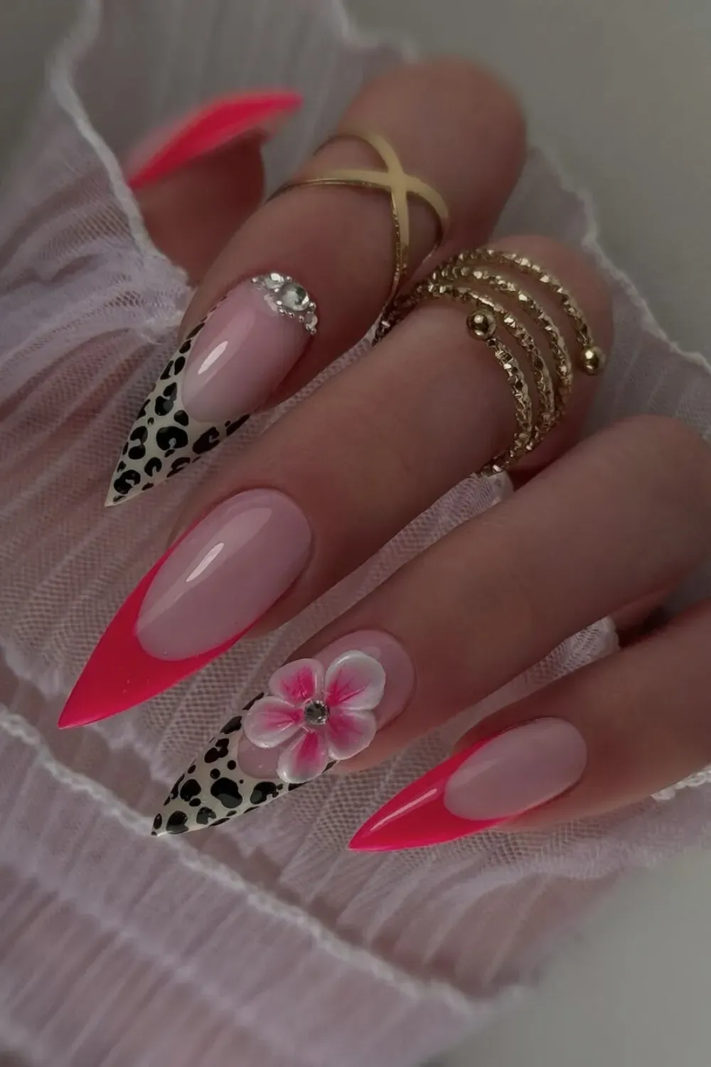 Pink And Leopard Stiletto Nails Alt Text: Hot pink french tips mixed with leopard print and 3D flowers.
