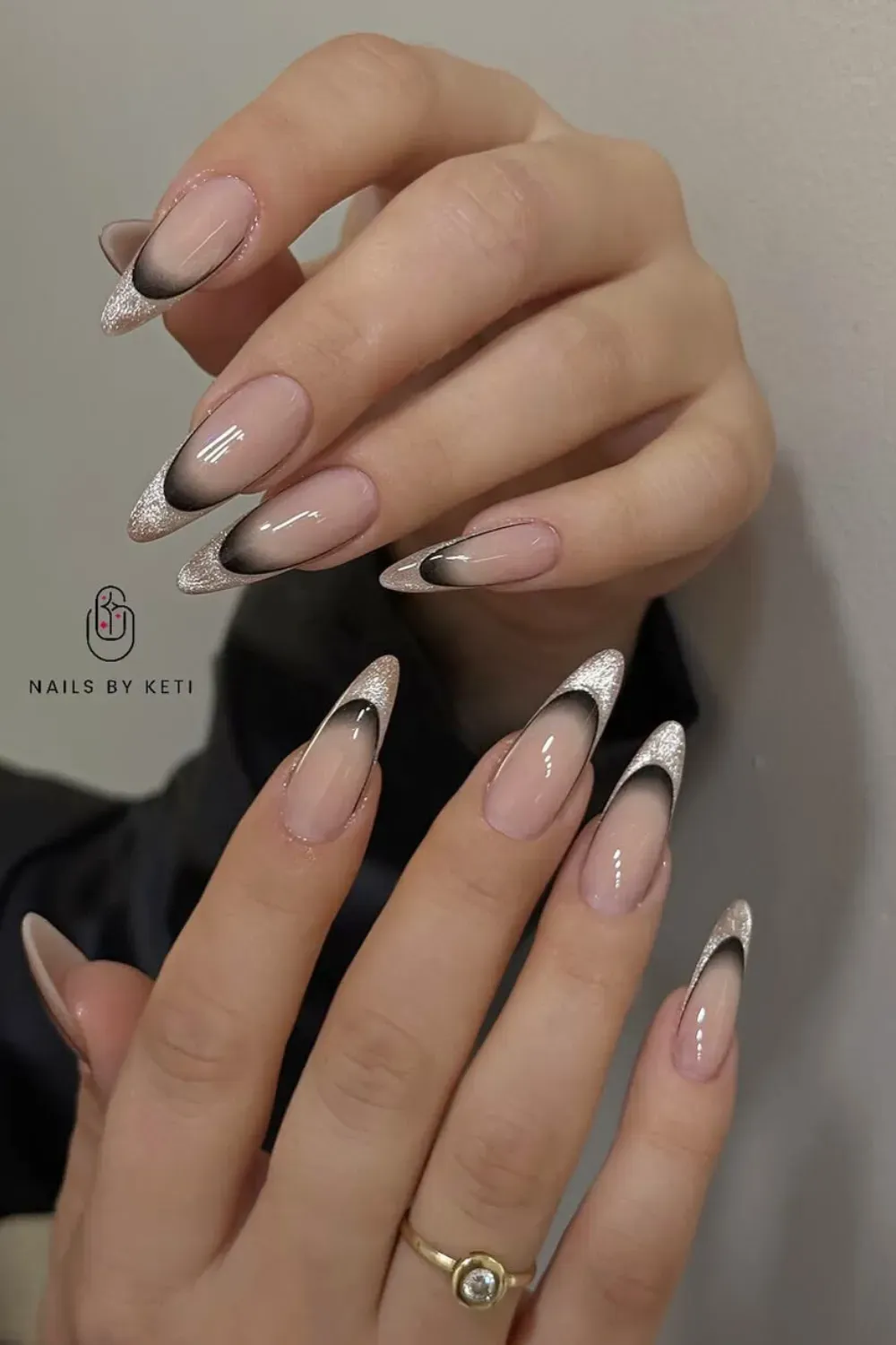 Glittery Ombre Black & Silver French: Long almond nails with black ombre French tips fading into silver glitter