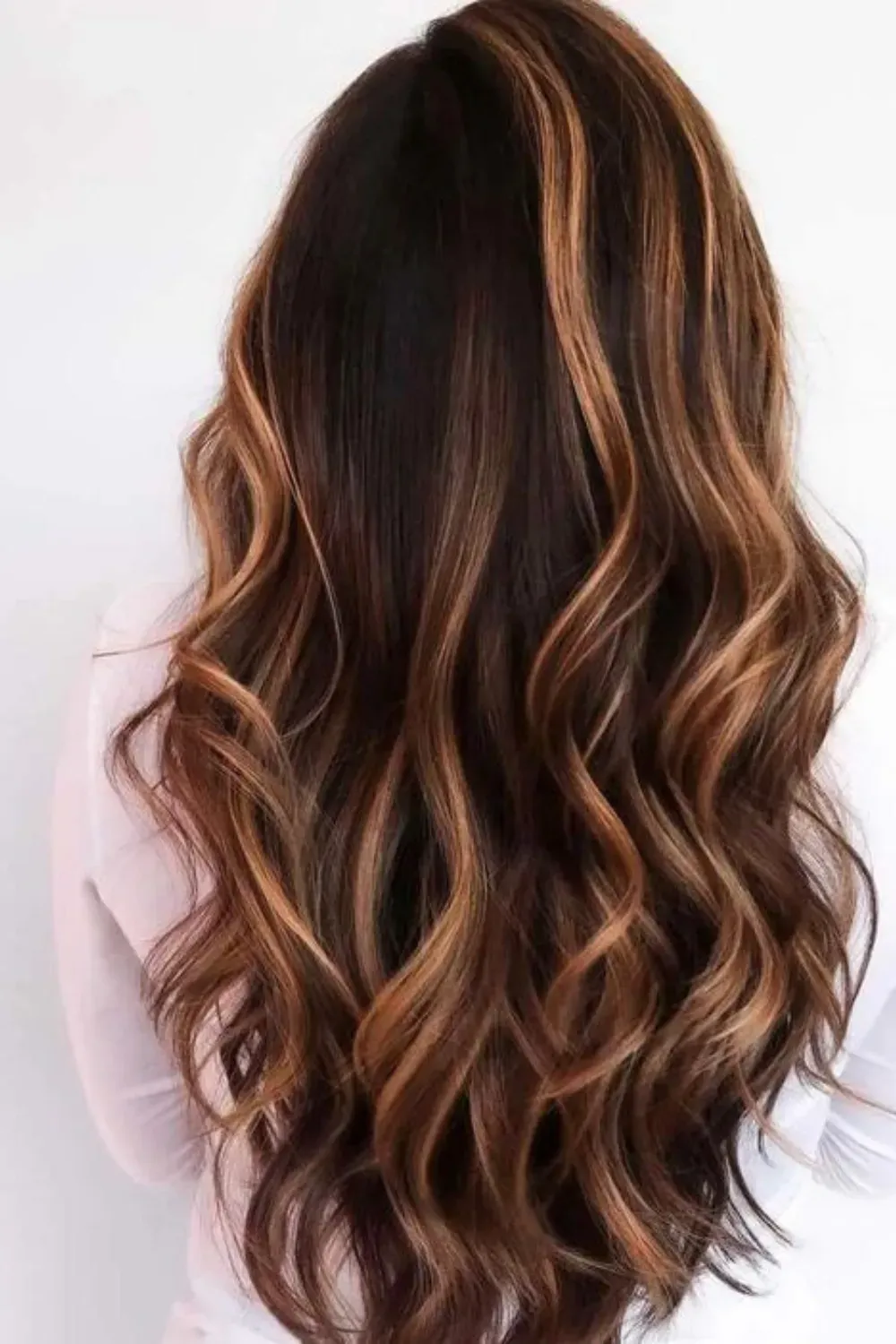 High-Contrast Caramel Ribbons on Soft Curls	Back view of long, soft curls featuring bold, ribbon-like streaks of bright caramel.