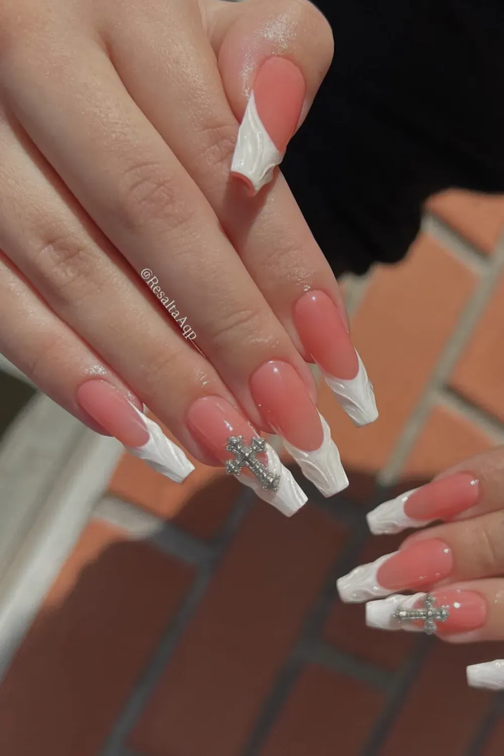 Textured Swirls With Cross Charm Alt Text: White 3D textured french tips with large silver cross charm.