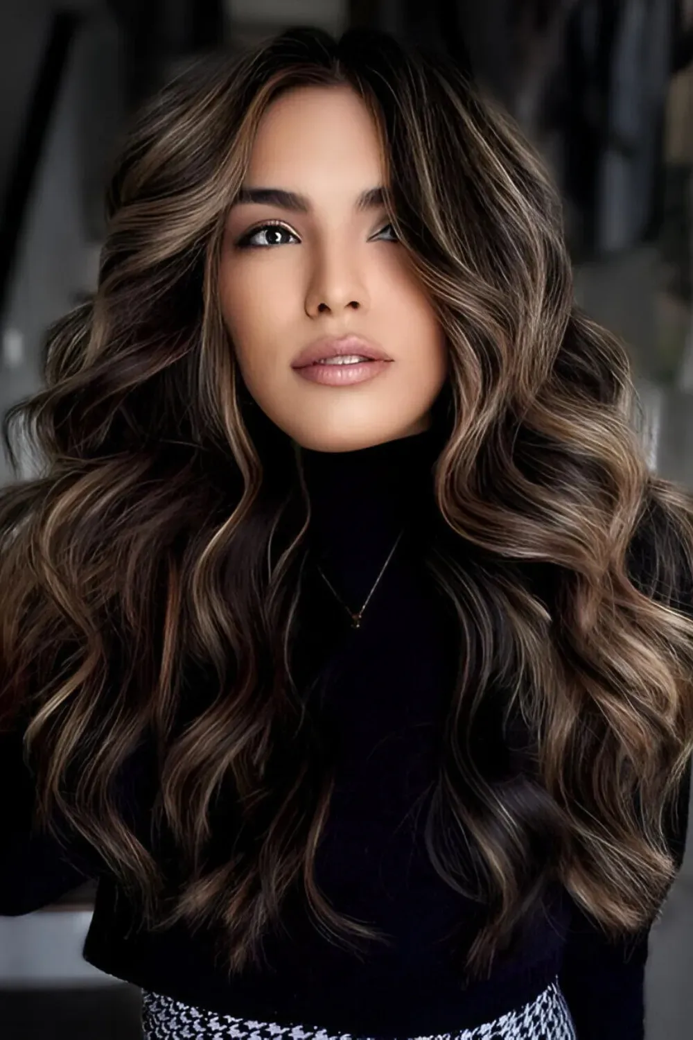 Voluminous All-Over Balayage	Woman with long, voluminous, dark hair and finely blended caramel balayage highlights for dimension.