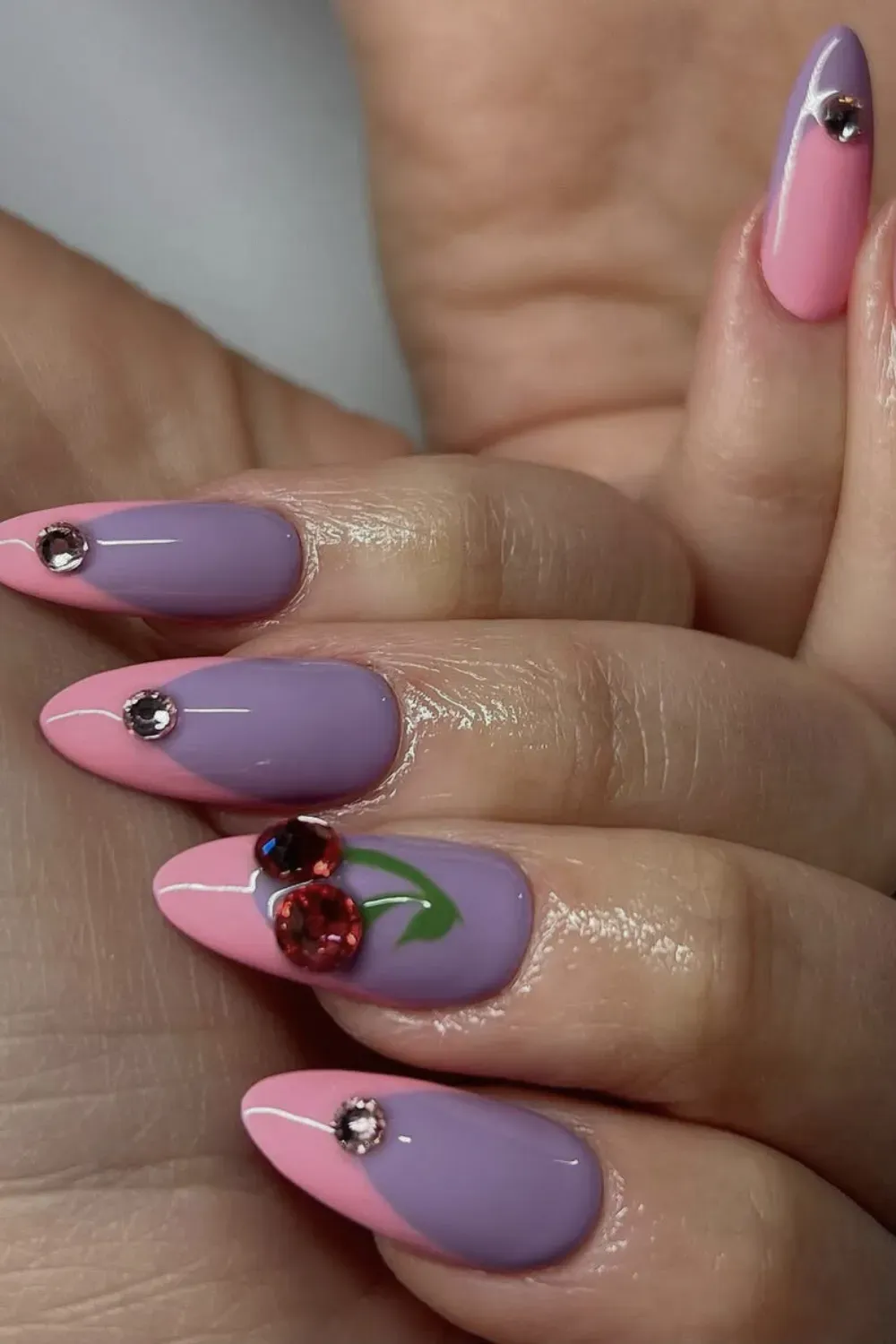 Purple Pink Two Tone French Alt Text: Two tone purple and pink french tips with cherry gem accent.
