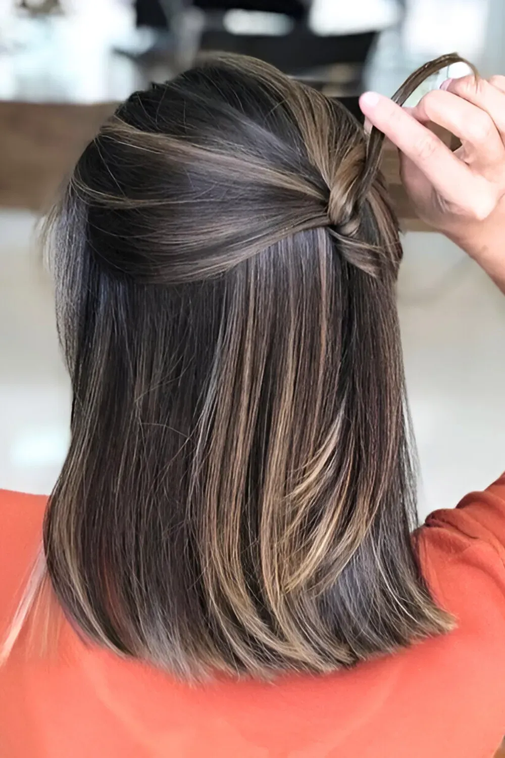 Polished Lob with Subtle Caramel Highlights	Back view of a straight lob with subtle caramel highlights and a small half-up twist detail.