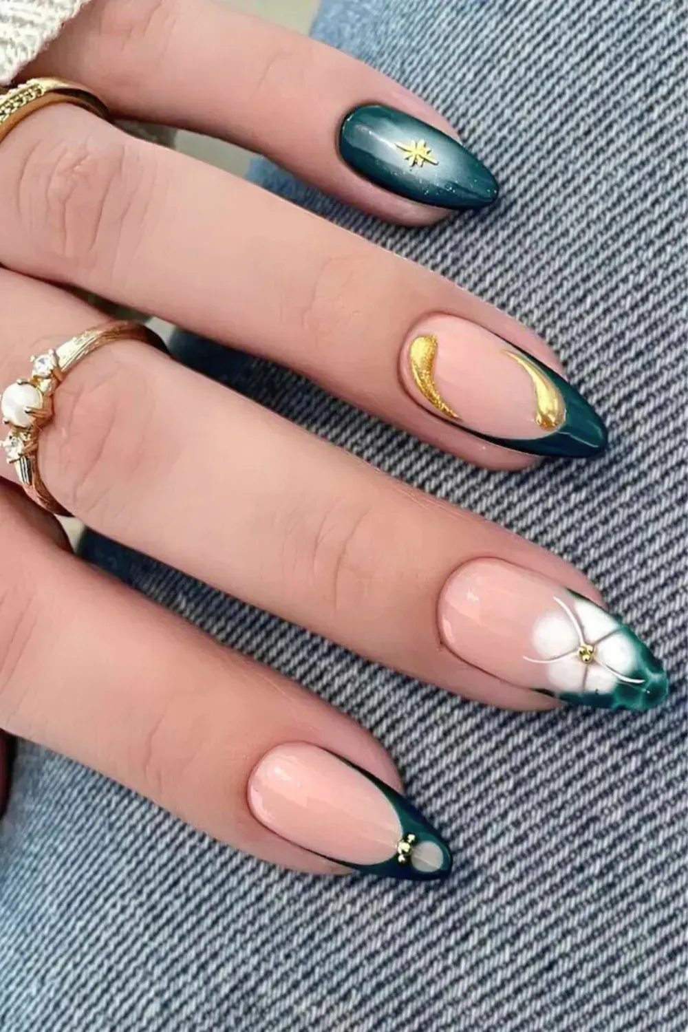 Emerald Green, Gold, and White Floral Mix-and-Match - Long almond nails mixing deep emerald French tips, gold swirls, and a white floral accent design.