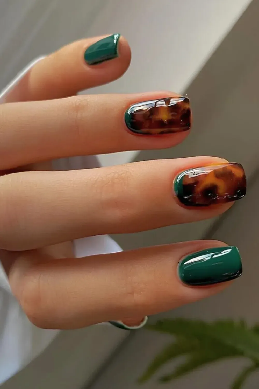 Emerald Green and Tortoise Shell Accent Manicure - Short square nails with solid emerald green and glossy accent nails featuring a brown tortoise shell pattern.