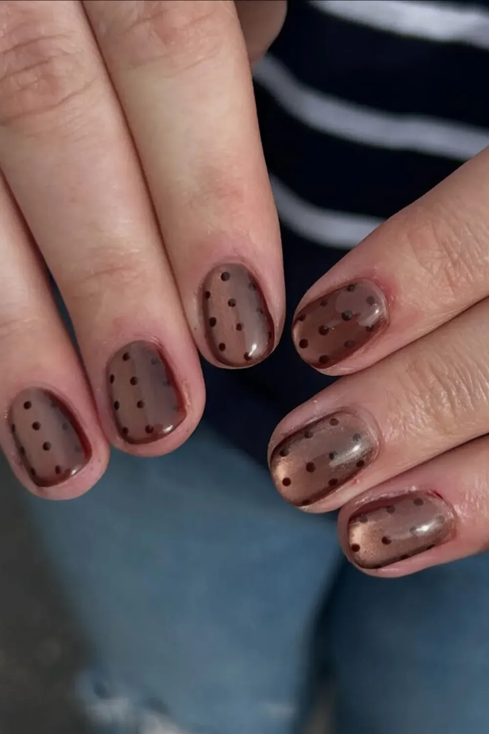 Rich brown magnetic nails accented with black polka dots on short nails.