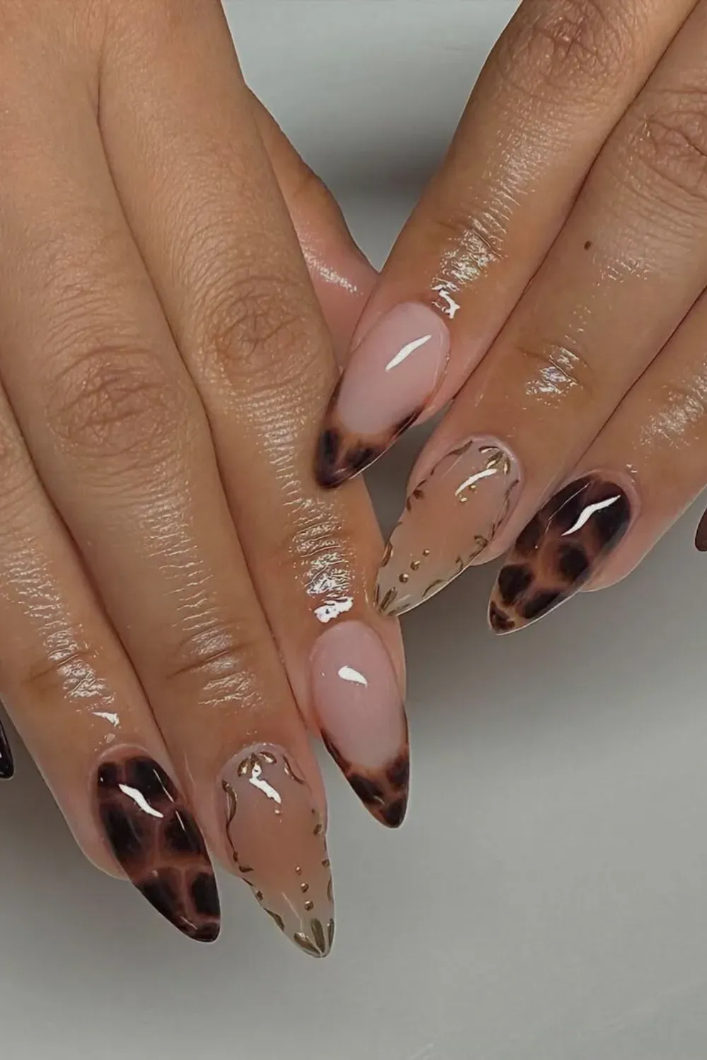 Tortoise Gold Chrome Nails Alt Text: Tortoise shell french tips with gold chrome abstract lines.