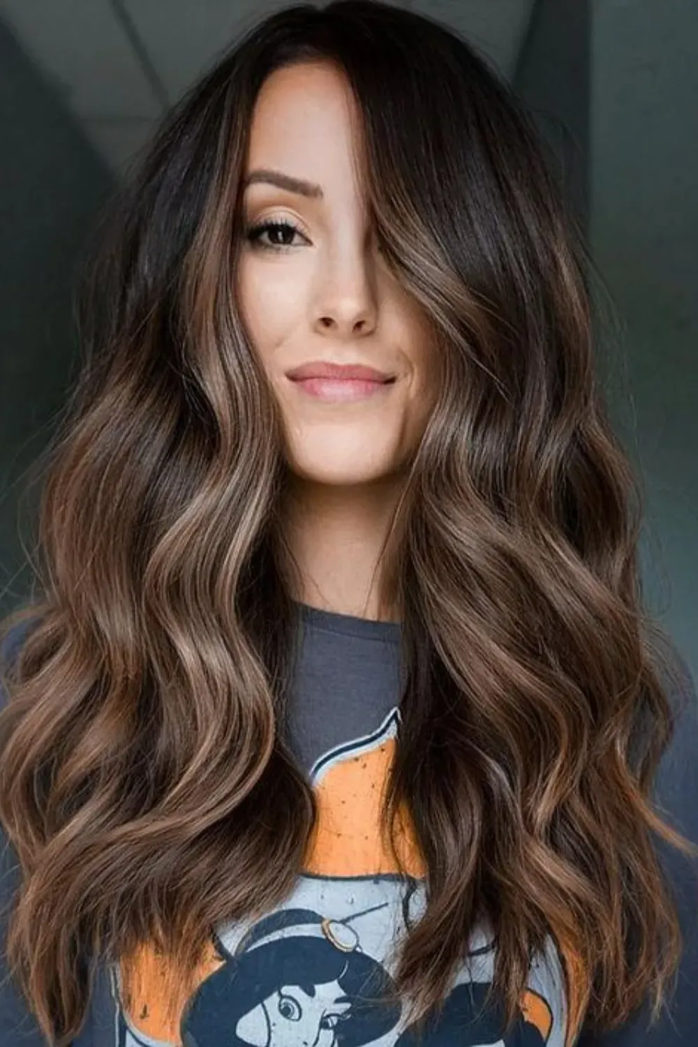 Cool Walnut Brown Hair with Subtle Caramel Balayage	Woman with long, wavy, cool-toned dark brown hair featuring muted walnut caramel highlights.