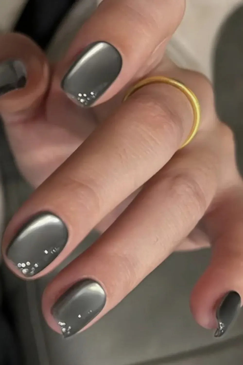 Short silver grey cat eye nails accented with small crystals at the cuticle