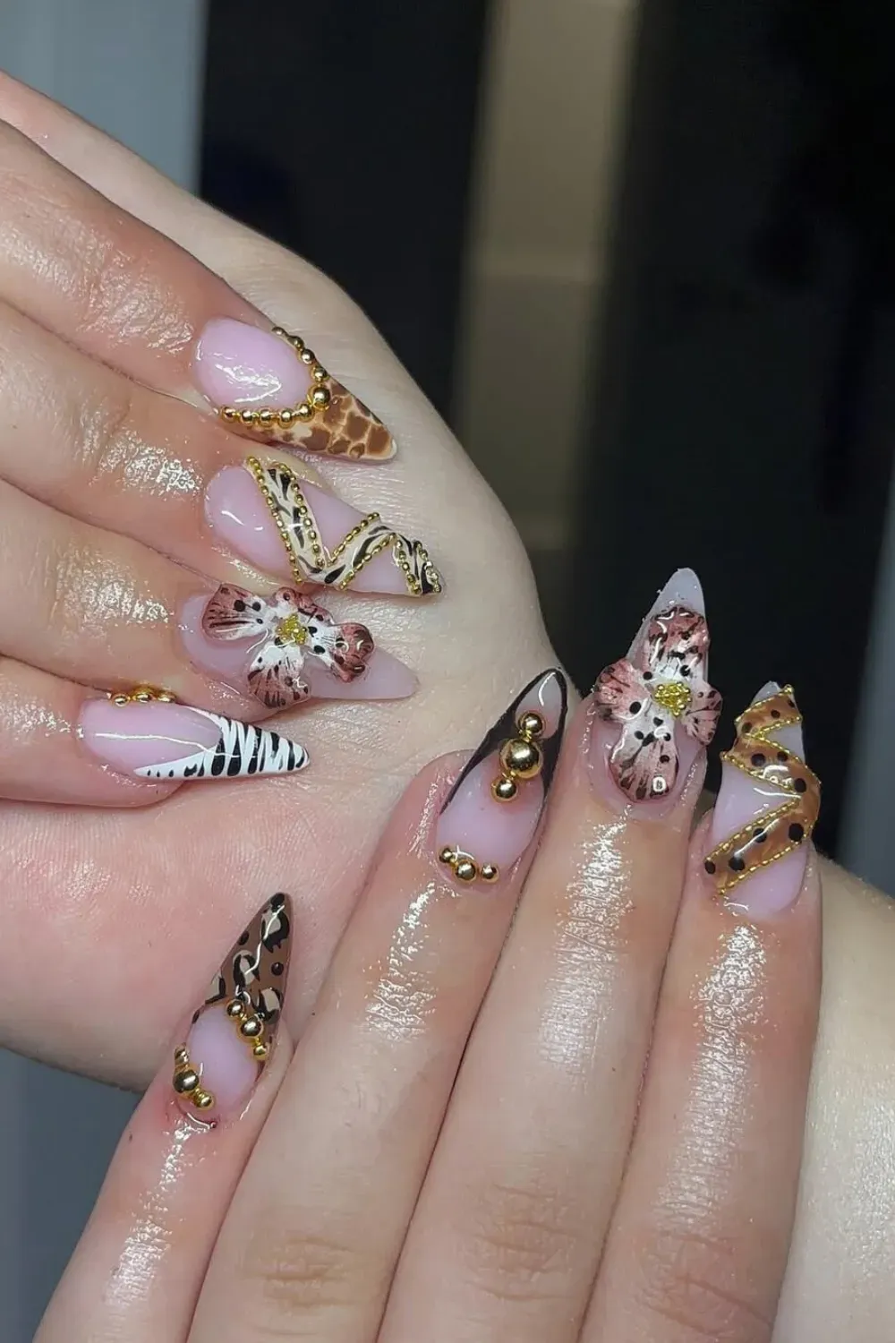 Safari-Chic Bangle Nails with Animal Prints and 3D Florals - Stunning Jewelry Nail Art set with cow print, leopard spots, gold 3D accents, and delicate sculpted floral attachments on pink-nude nails.