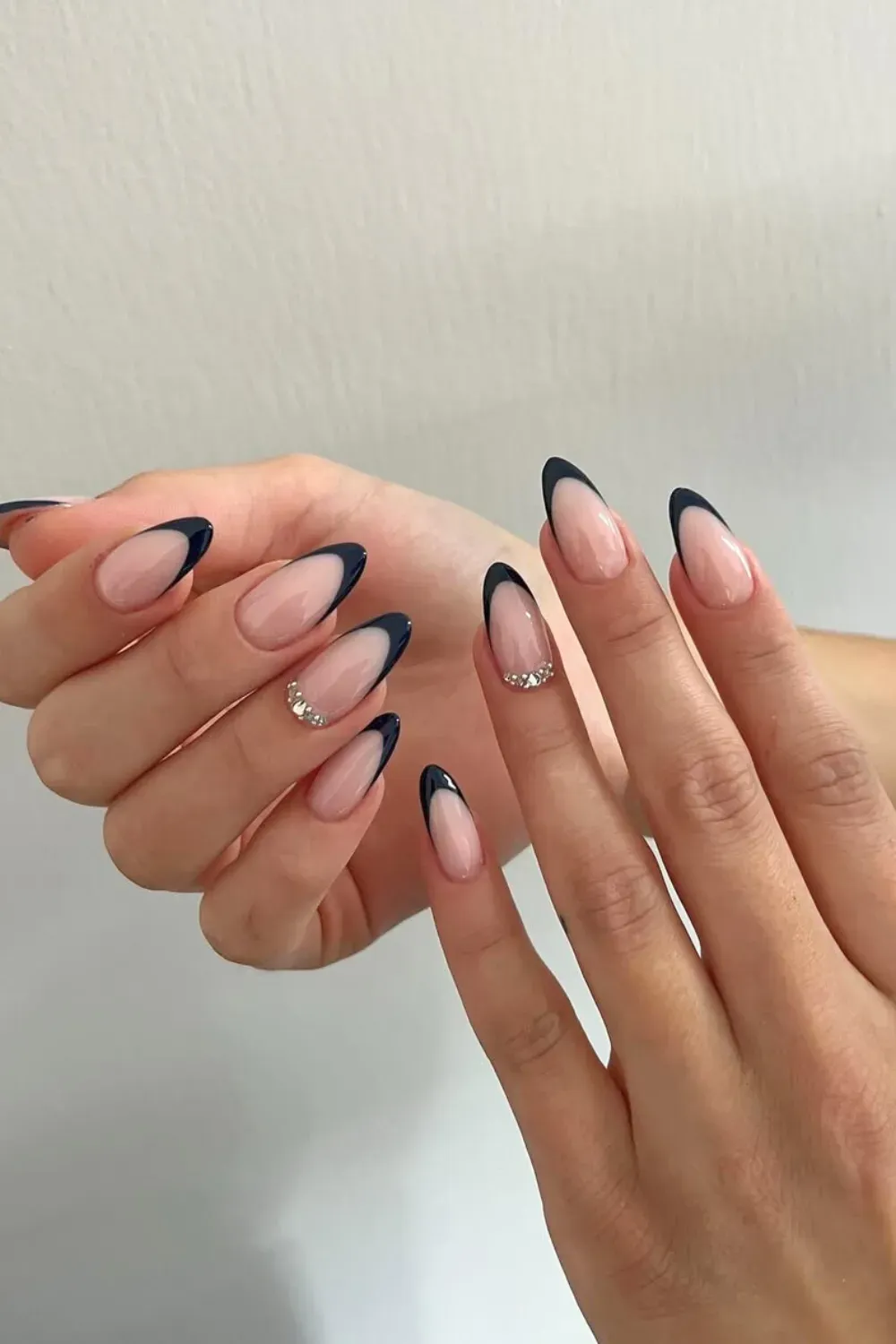 Sleek Black V-Shape French with Rhinestones: Almond nails with a striking V-shaped black French tip and sparkling rhinestones.