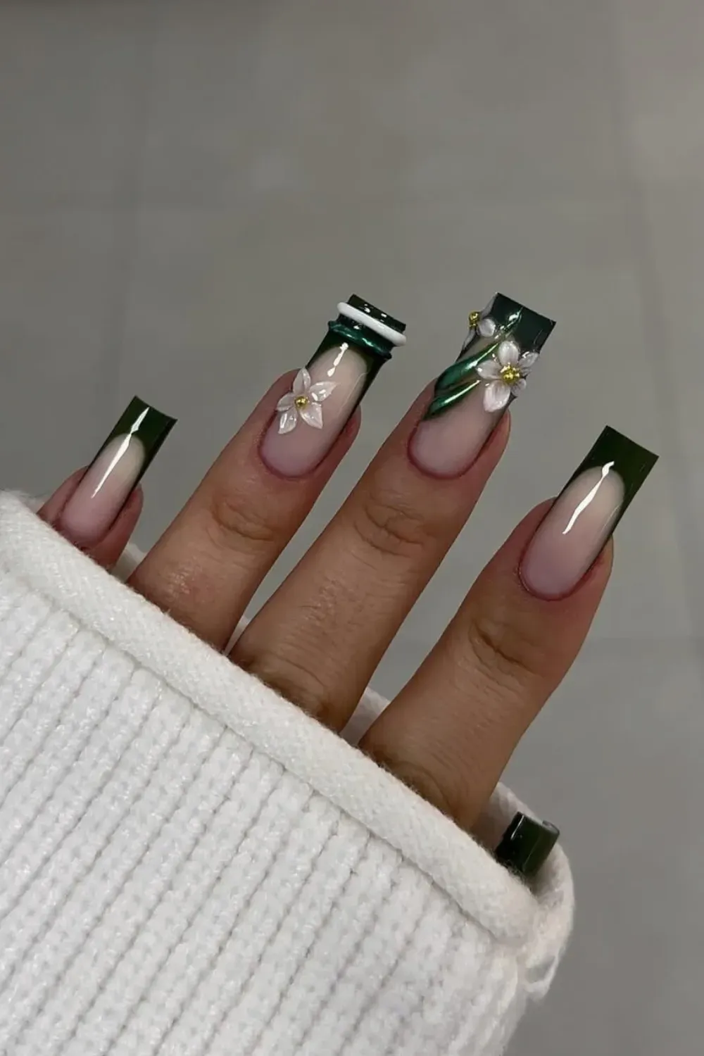 Green French With 3D Flower Alt Text: Dark green french tip nails with large white 3D flower and gold beads.