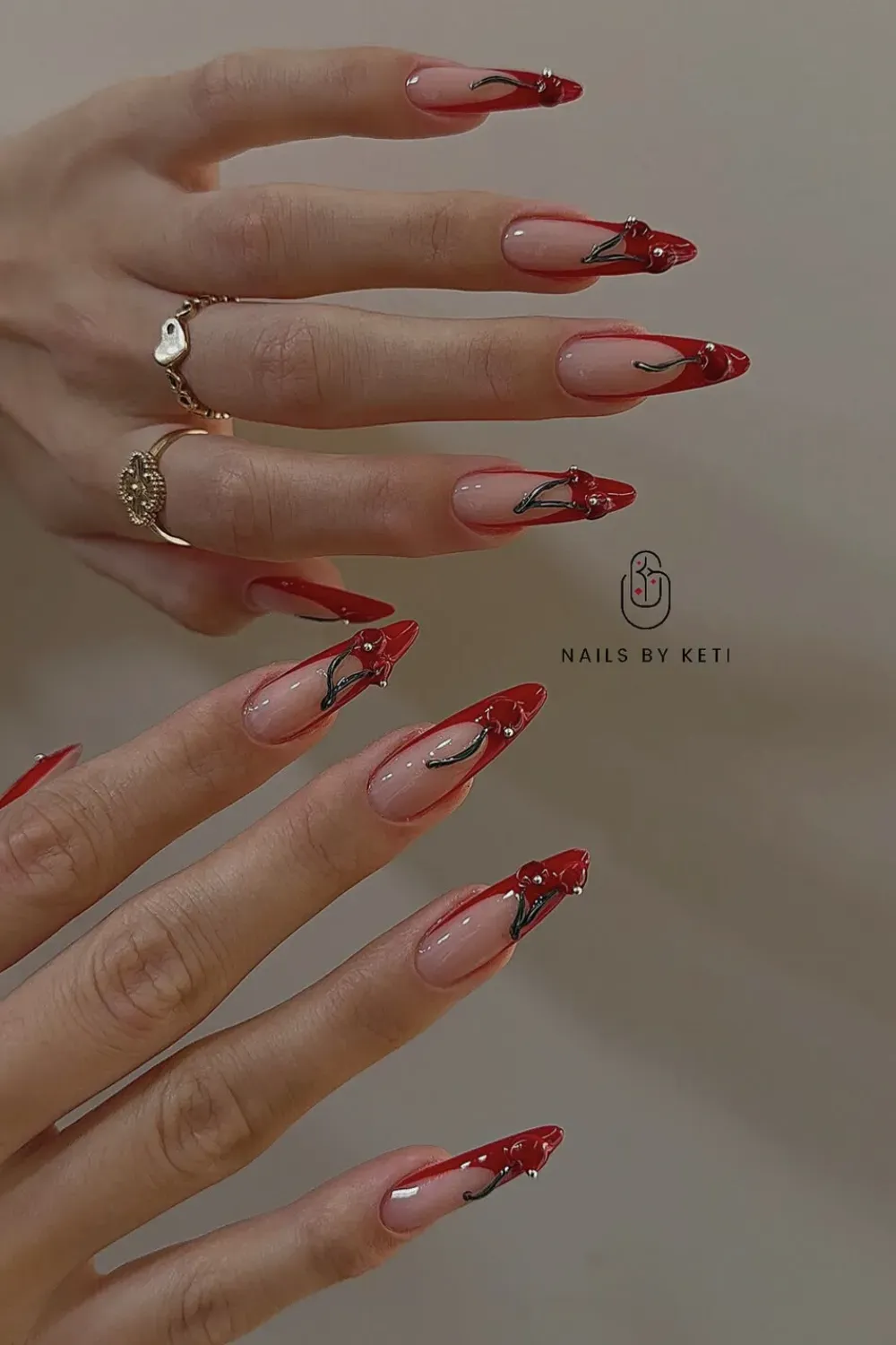 Red French With 3D Cherries Alt Text: Stiletto nails with red tips and silver stemmed 3D cherry art.