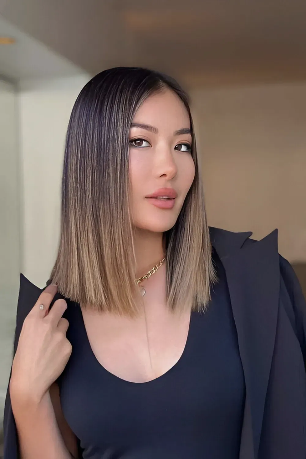 Sleek Straight Bob with Caramel Ombre	Woman with a sharp, straight bob where the color transitions to a neutral caramel ombre near the ends.