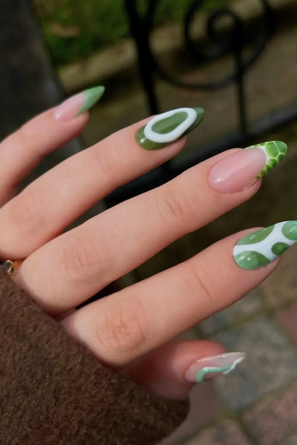 Abstract Green and White Cow Print French Tips - Medium almond nails with modern French tips and full-coverage nails featuring abstract green and white cow print and swirls.