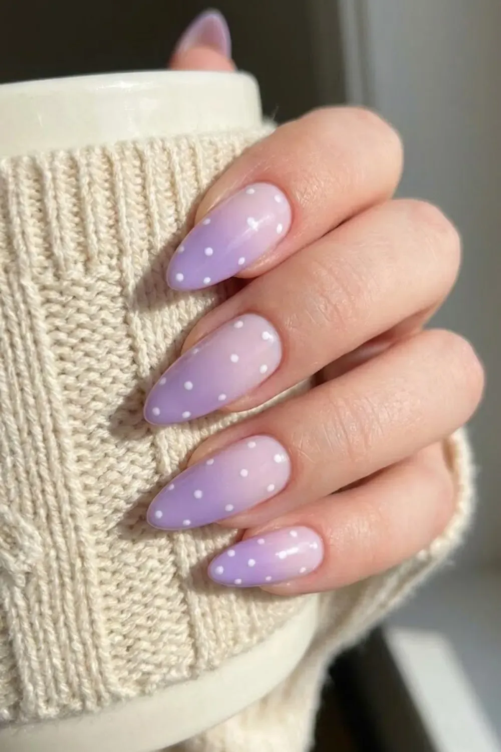 Purple Gradient Polka Dot Nails - Hand holding a mug displaying purple ombré almond nails with small white polka dots.