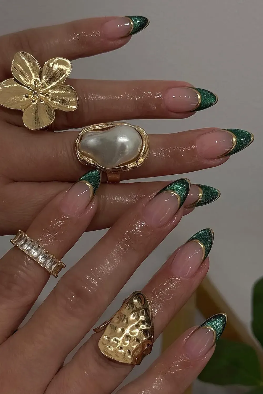 Green Glitter French Tips Alt Text: Almond nails with emerald green glitter french tips and gold outline.