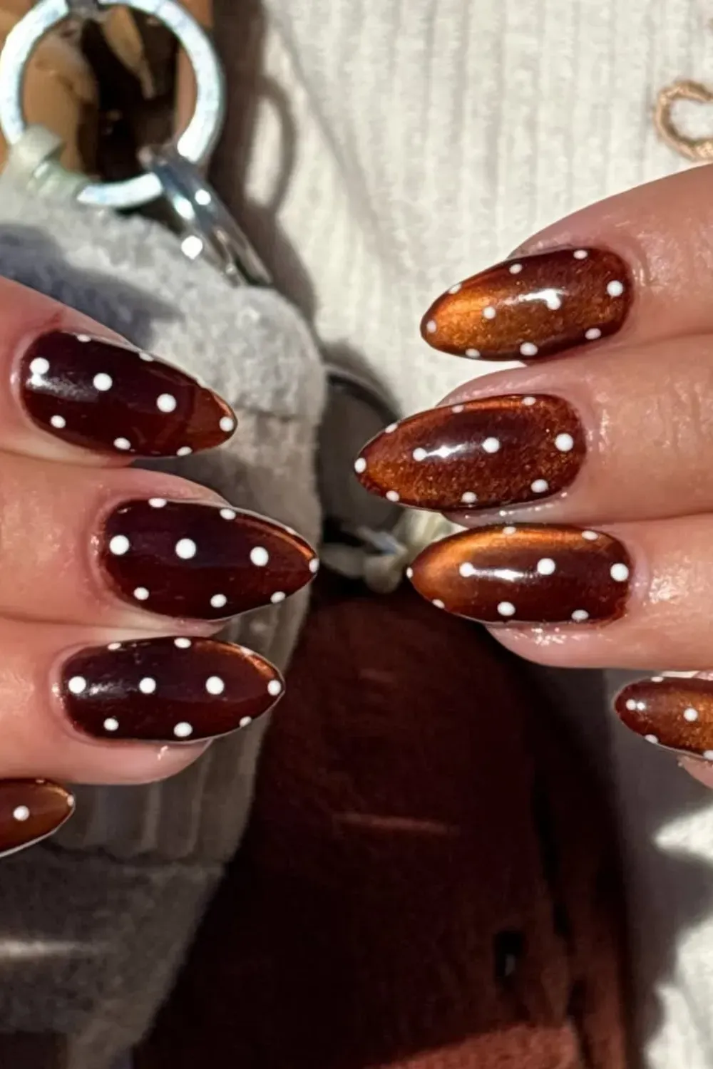 Cat Eye Polka Dot Combo - Almond-shaped nails featuring a mix of shimmering copper-brown cat eye polish and dark burgundy nails with crisp white polka dots.