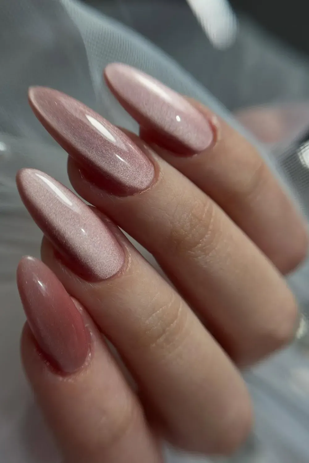 Chic & Glimmering Neutrals - Long, elegant almond nails in a soft nude-pink tone with a subtle, shimmering pink cat eye effect down the center