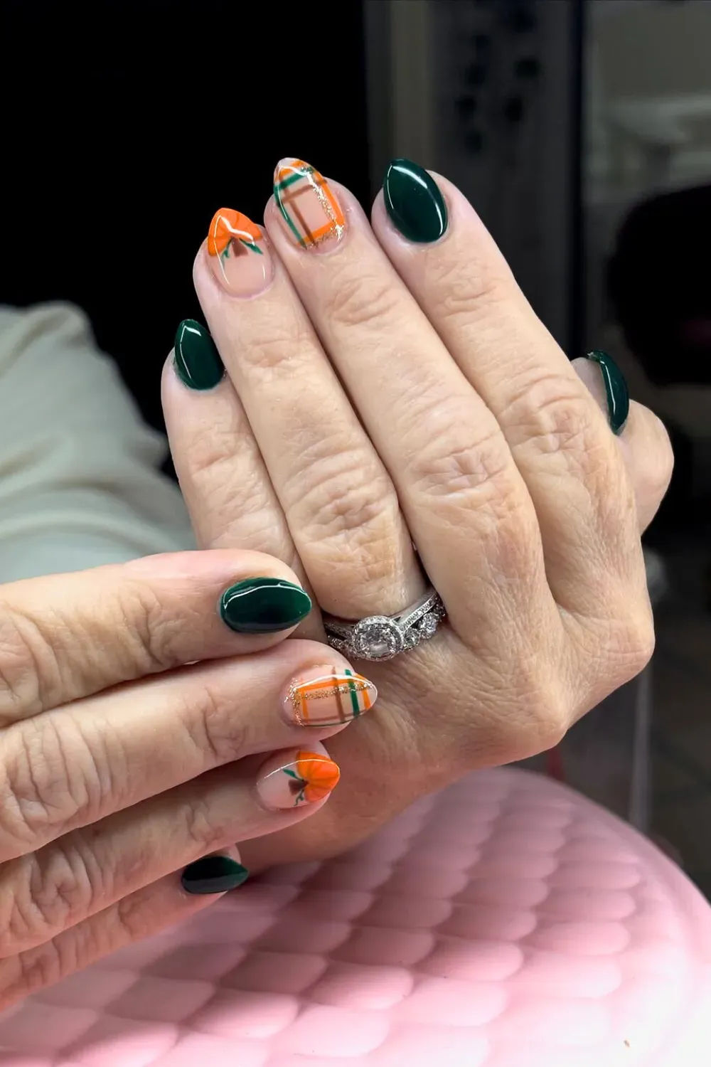 Emerald Green and Orange Plaid Fall Nails - Oval nails with solid deep emerald green and nude accent nails featuring vibrant orange and green plaid patterns.