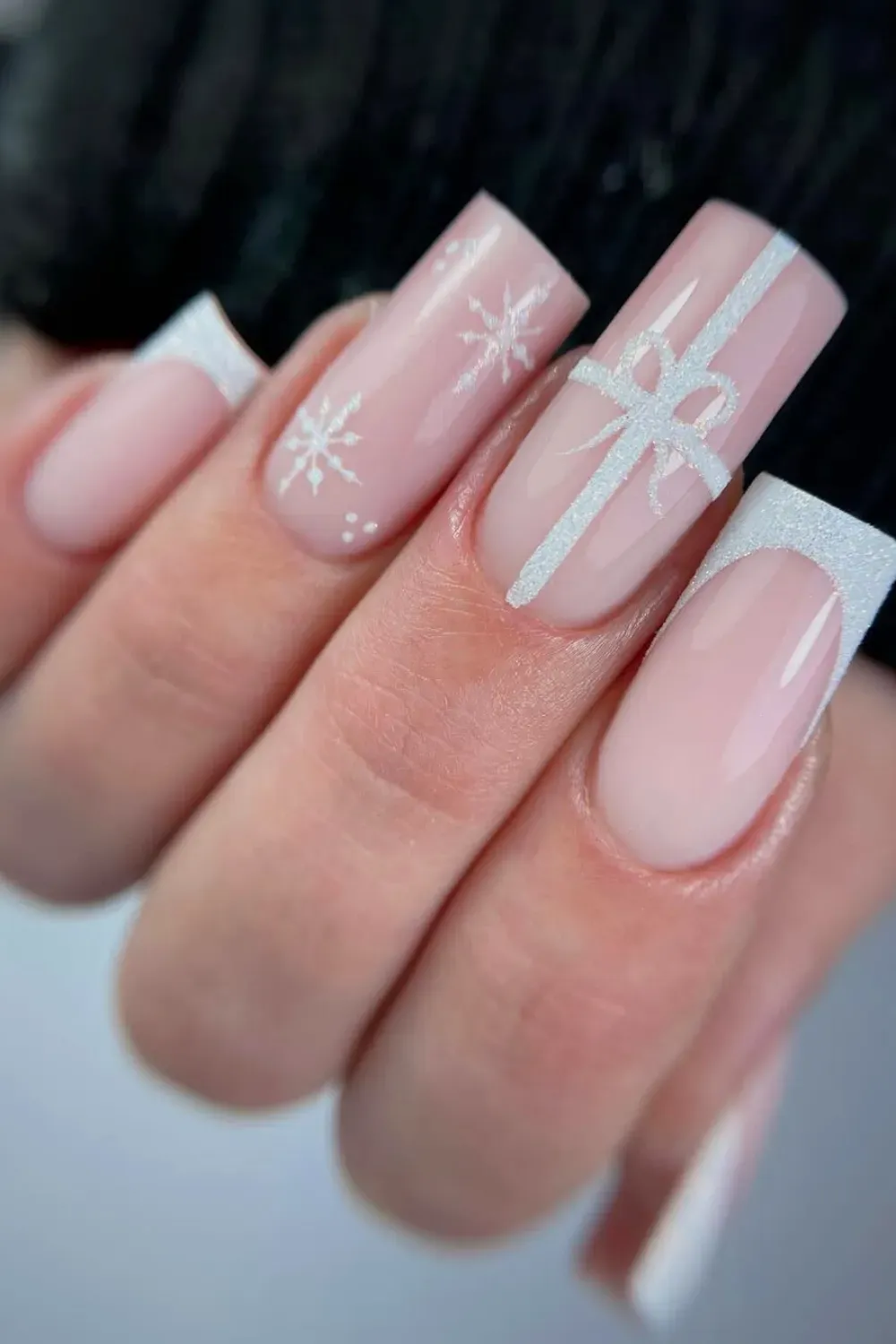Sheer Pink Nails with White Glitter Gift Bow - Square nails with a sheer pink base, a large sparkling white glitter gift bow, and snowflakes
