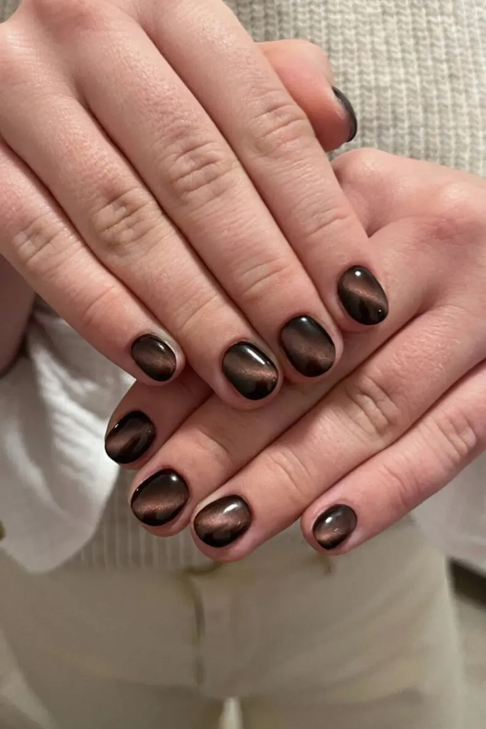 Cozy Brown Shorties - Short, round-oval nails coated in a warm, glossy, deep-chocolate brown cat eye polish, styled for a cozy winter look.