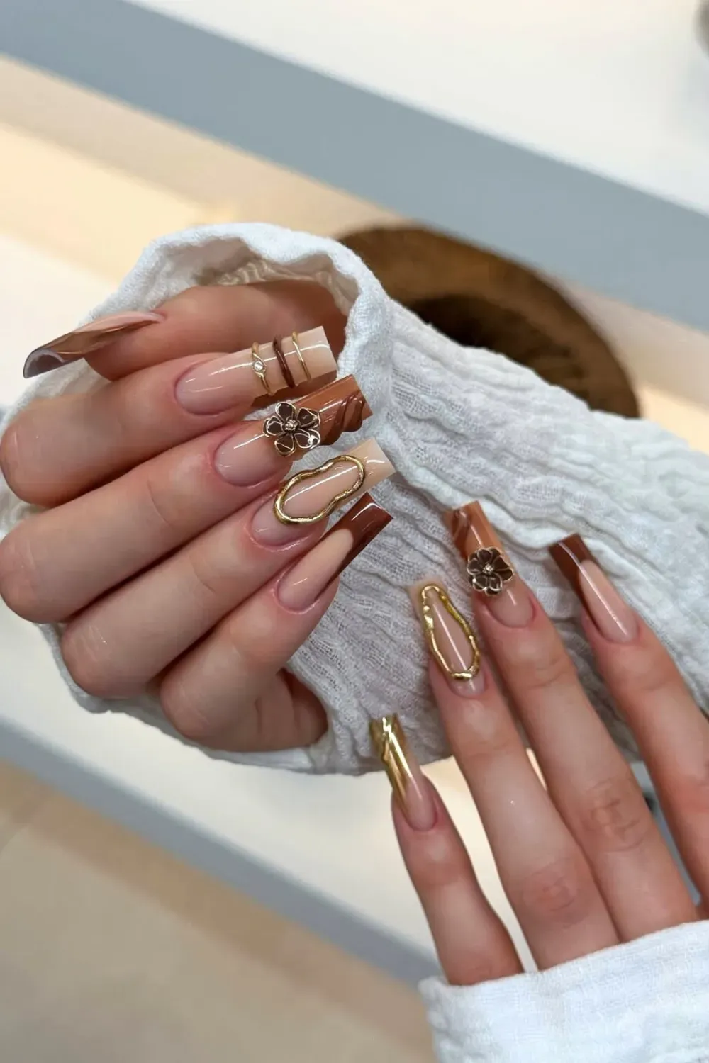 Jelly Brown French Tip with Gold Glitter Hands showcasing square-coffin nails with a nude base and a glossy, translucent deep brown French tip, accented by a subtle line of gold glitter/foil.