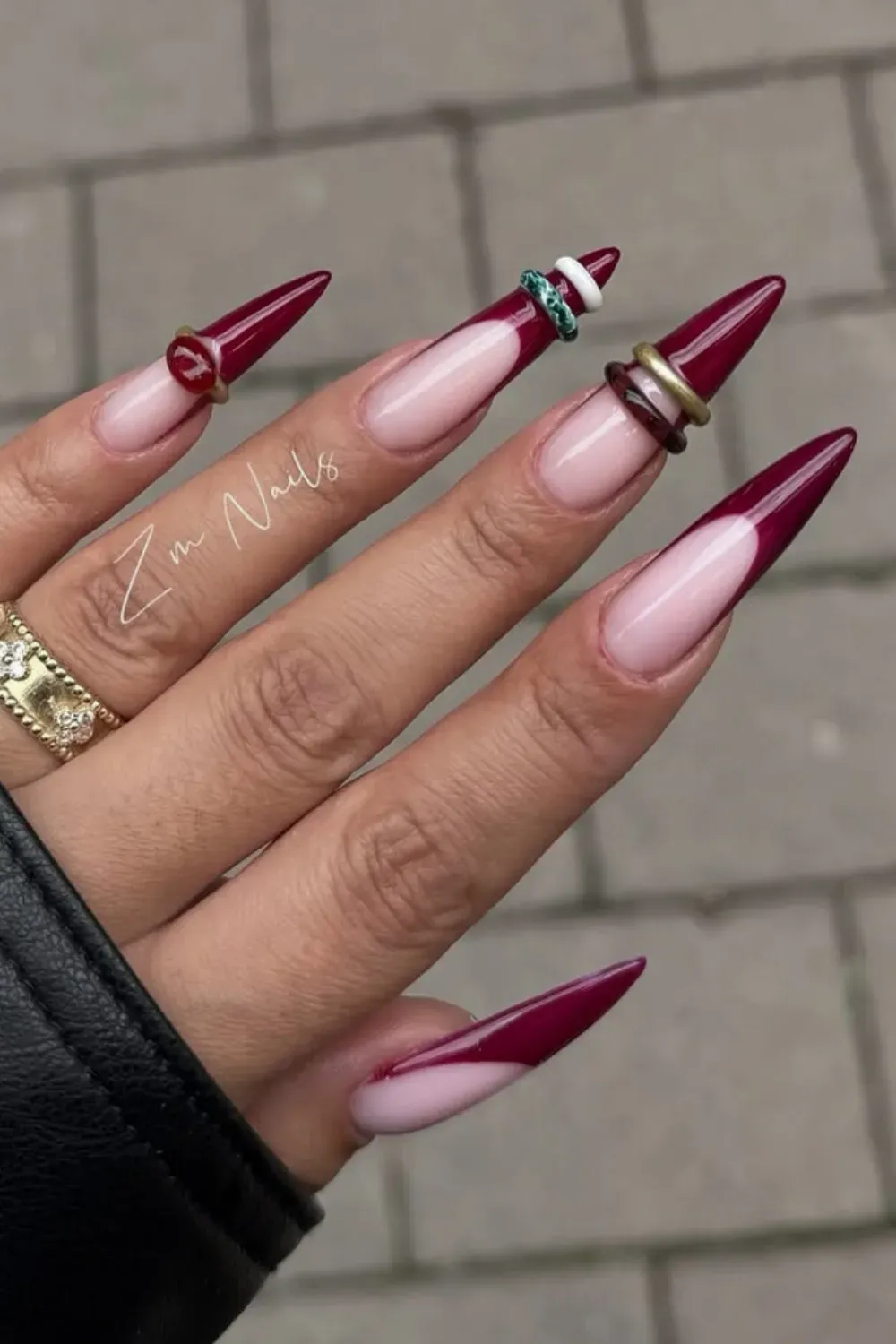 Deep Red French Stiletto Nails with Rings - Stiletto nails with deep red French tips accessorized with stacked finger rings.