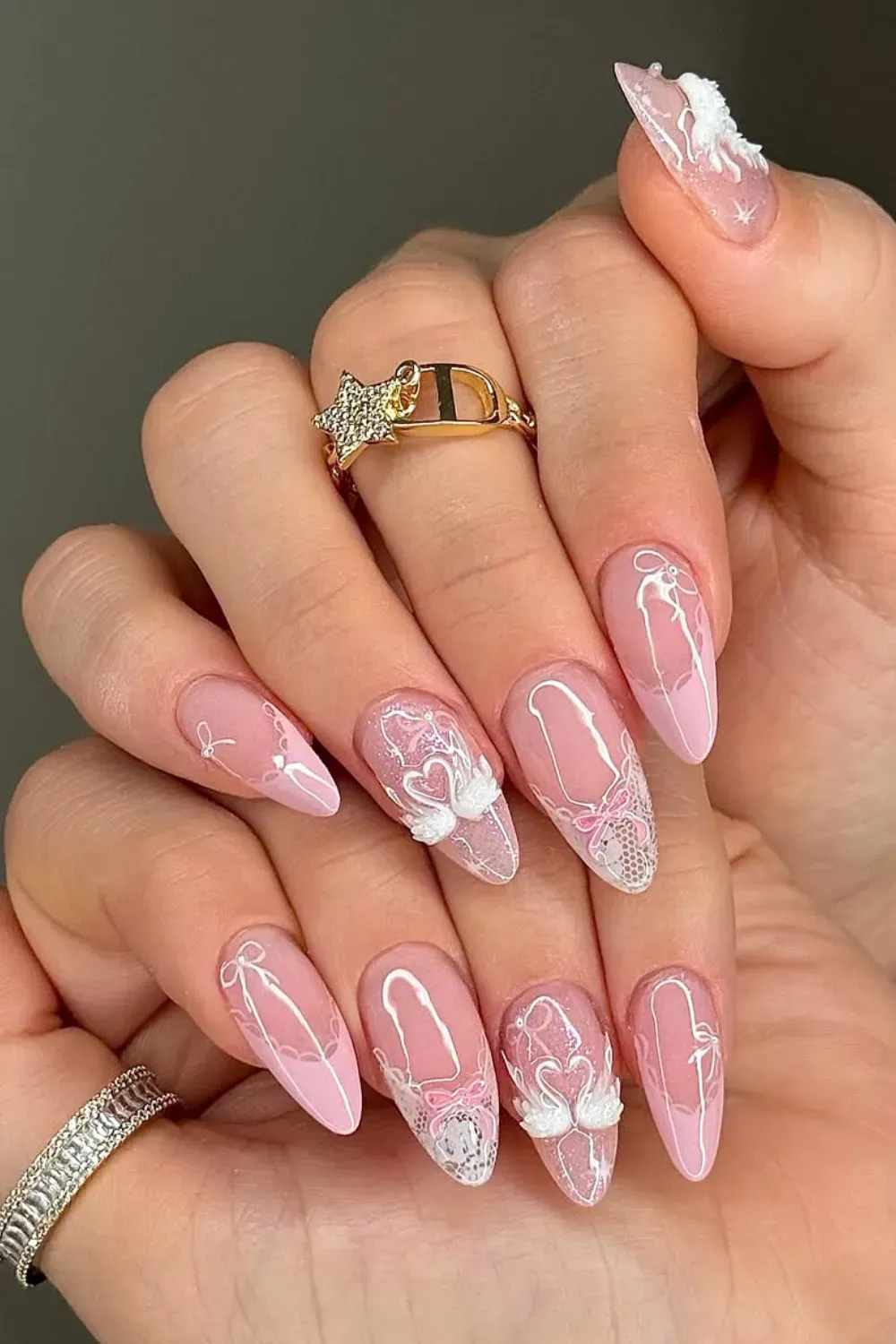 Sheer Pink Nails with Swan and Bow Art - Almond nails with a sheer pink base and delicate white swan and bow nail art
