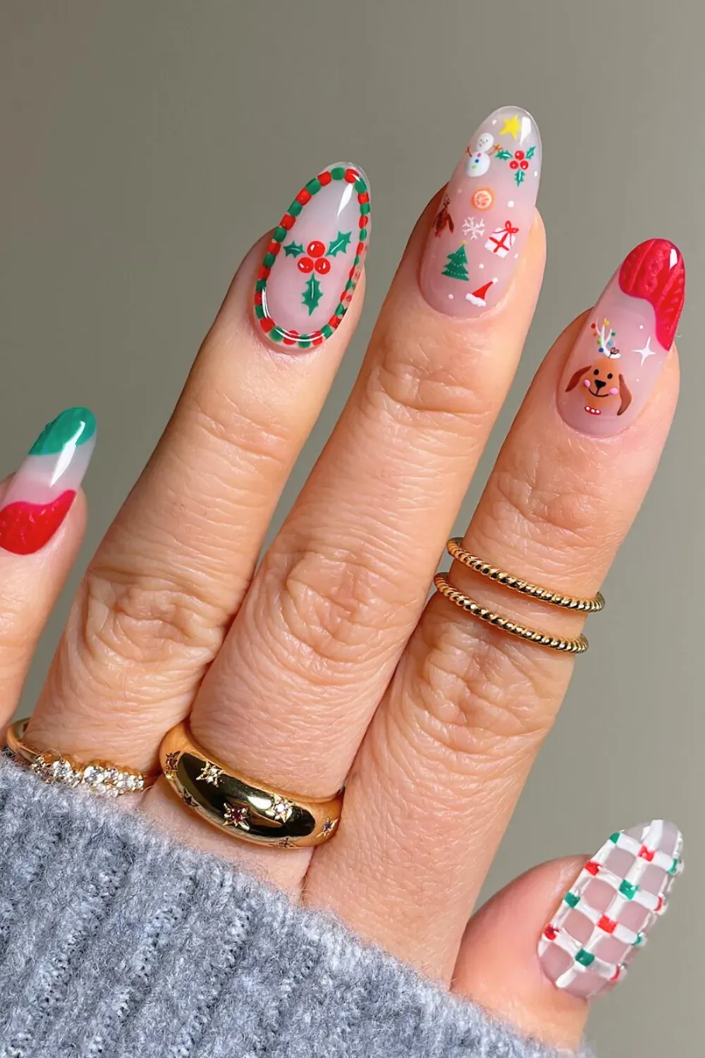 Sheer Nails with Mix of Christmas Icons - Almond nails with a sheer base covered in various small Christmas icons like a wreath and reindeer.