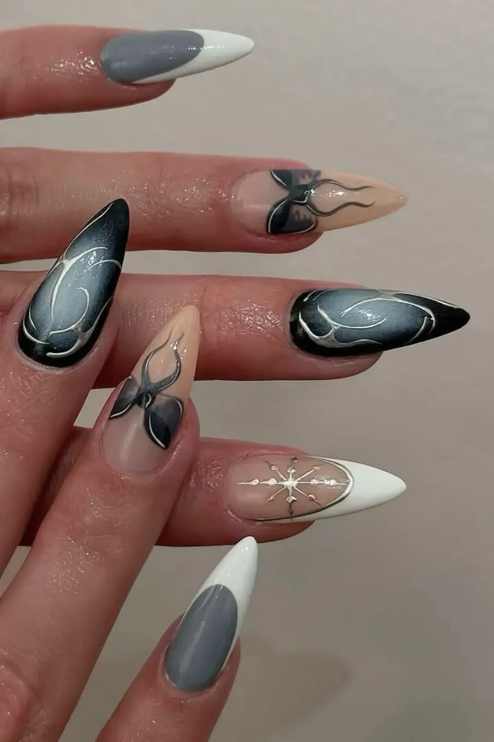 Black Airbrush Stiletto Nails with Silver Stars - Stiletto nails with a black and grey airbrush design highlighted by silver star outlines.