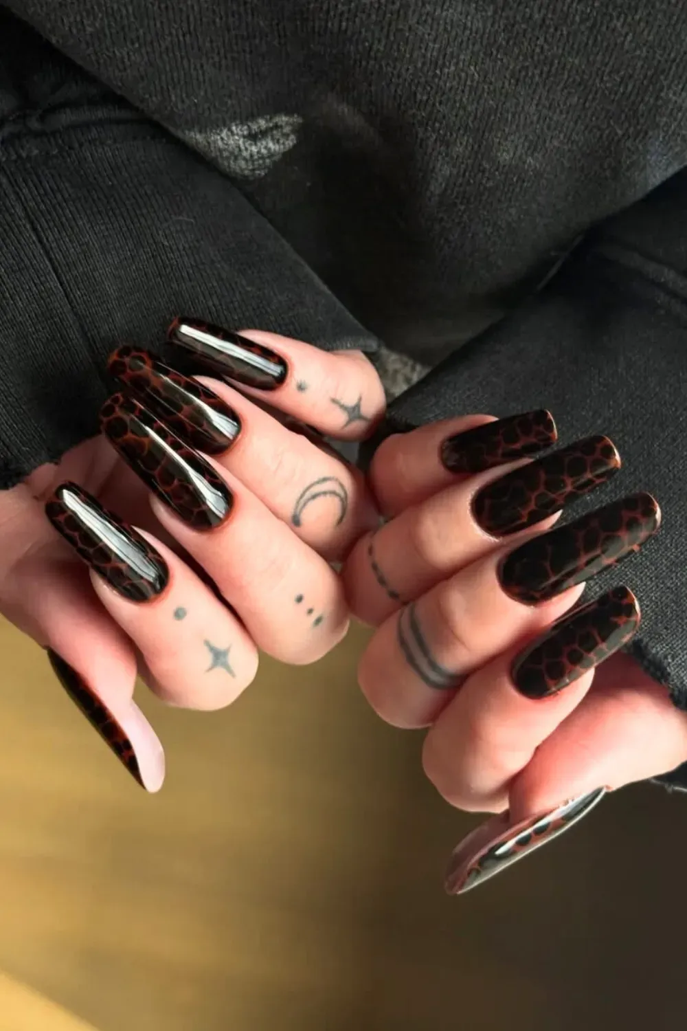 Long coffin nails featuring a high-gloss, dark brown and black tortoiseshell pattern.