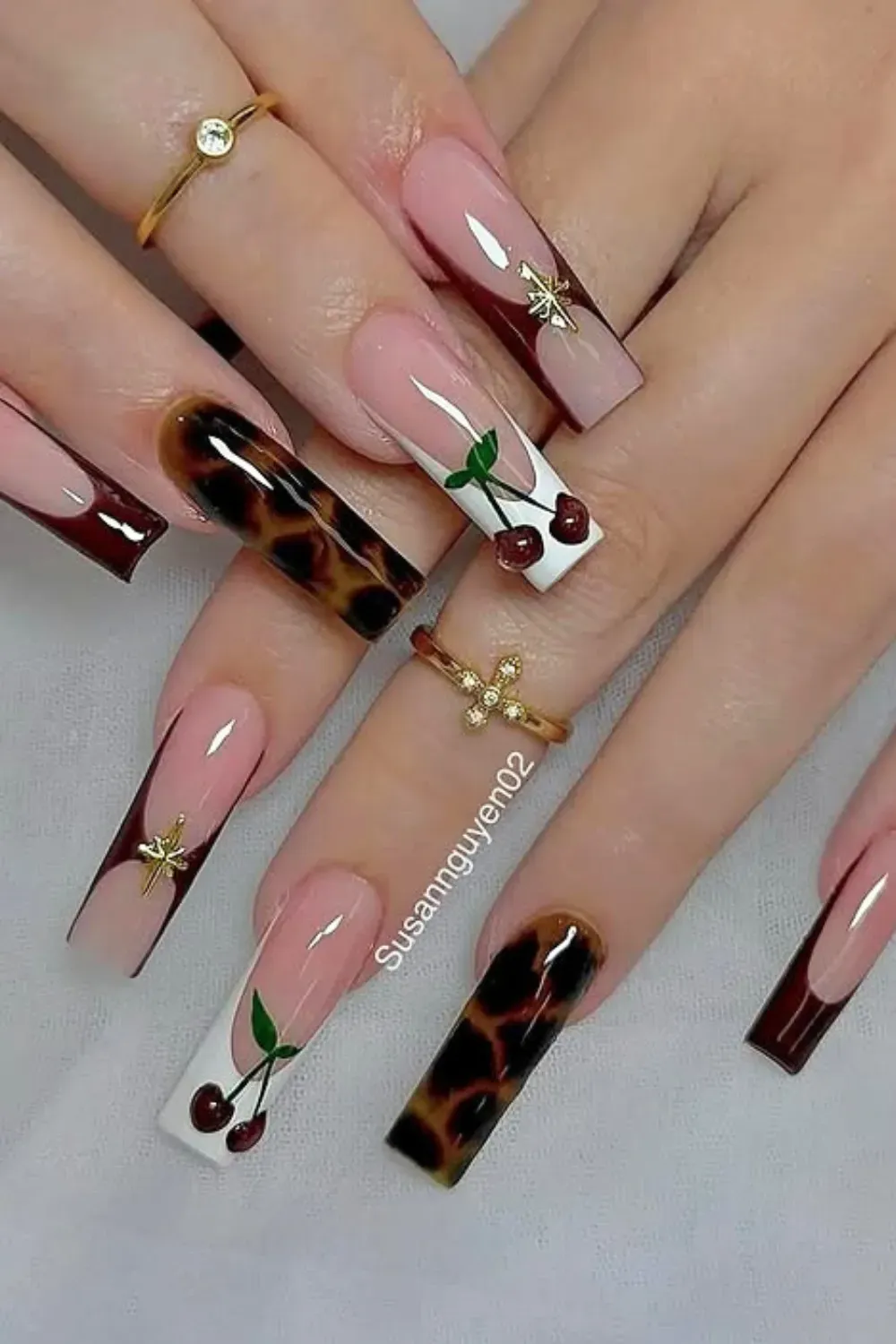 Cherry and Tortoiseshell French Manicure Ultra-long square nails featuring a blend of dark red French tips, tortoiseshell print nails, and white French tips with painted cherry art and small gold star charms.