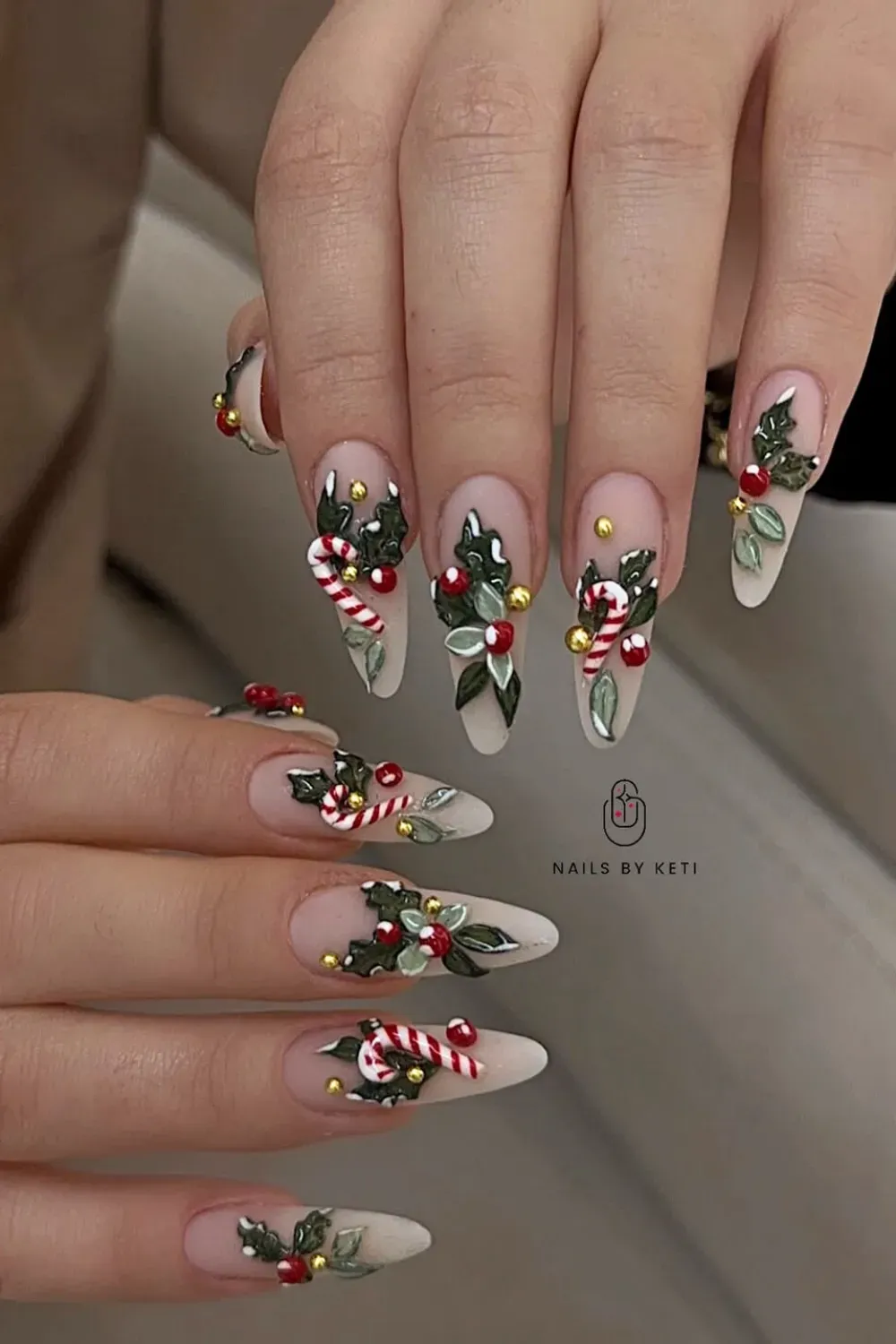 Matte Nude Nails with 3D Holly and Candy Canes - Stiletto nails with a matte nude base, 3D candy canes, holly leaves, and gold beads