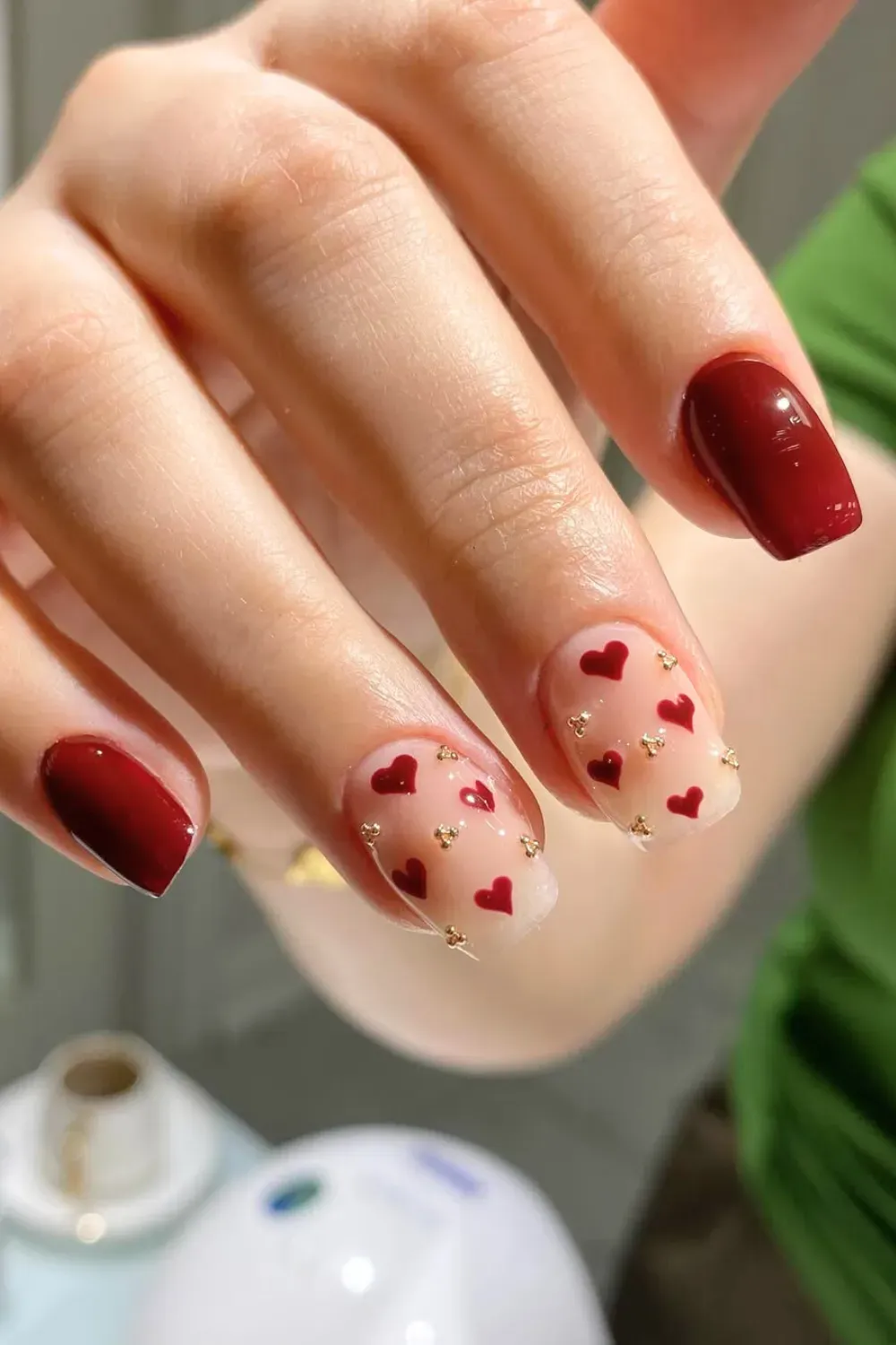 Nude Nails with Tiny Red Hearts - Short square nude nails decorated with minimalist tiny red hearts and gold studs.